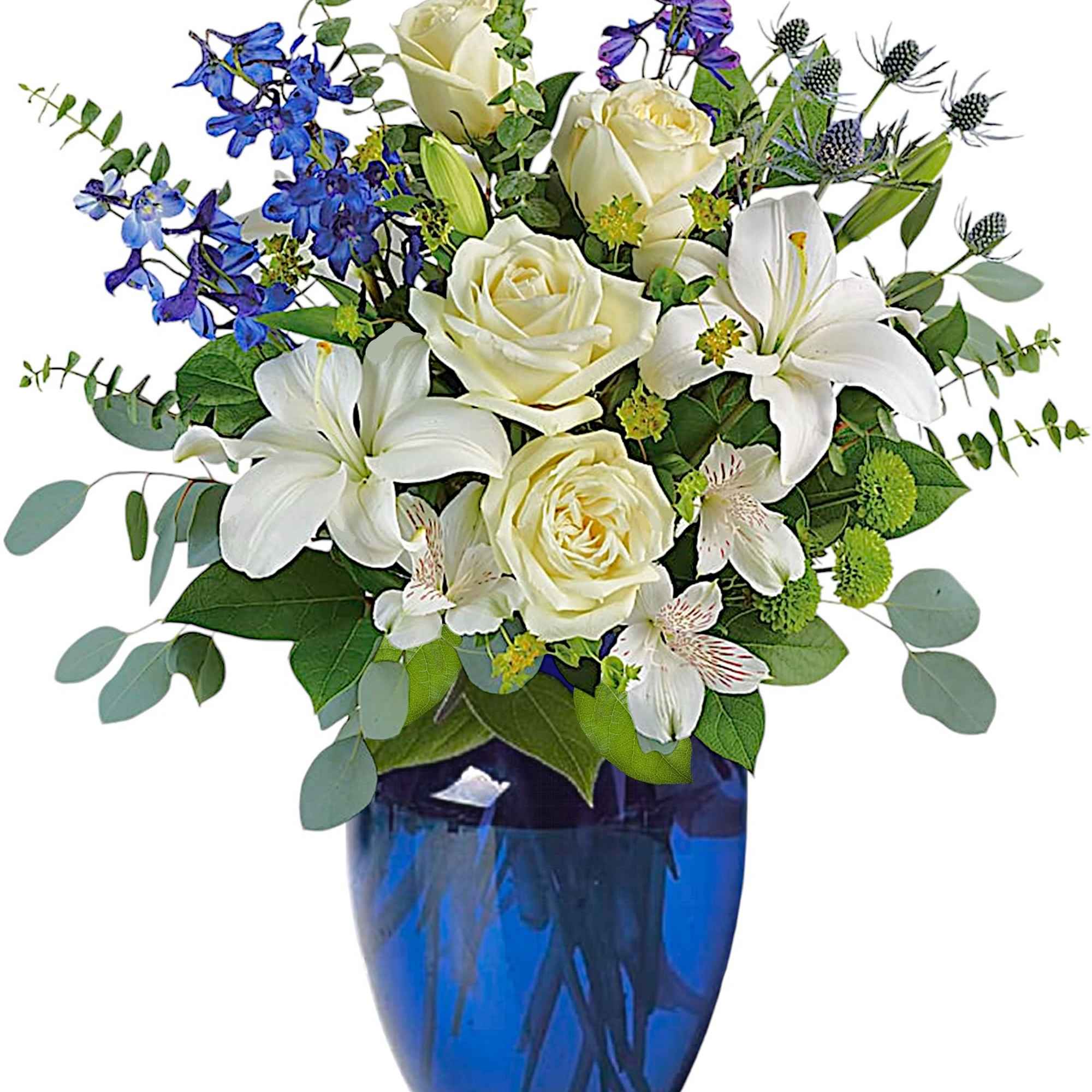 White roses and lilies in a blue glass vase with blue flowers