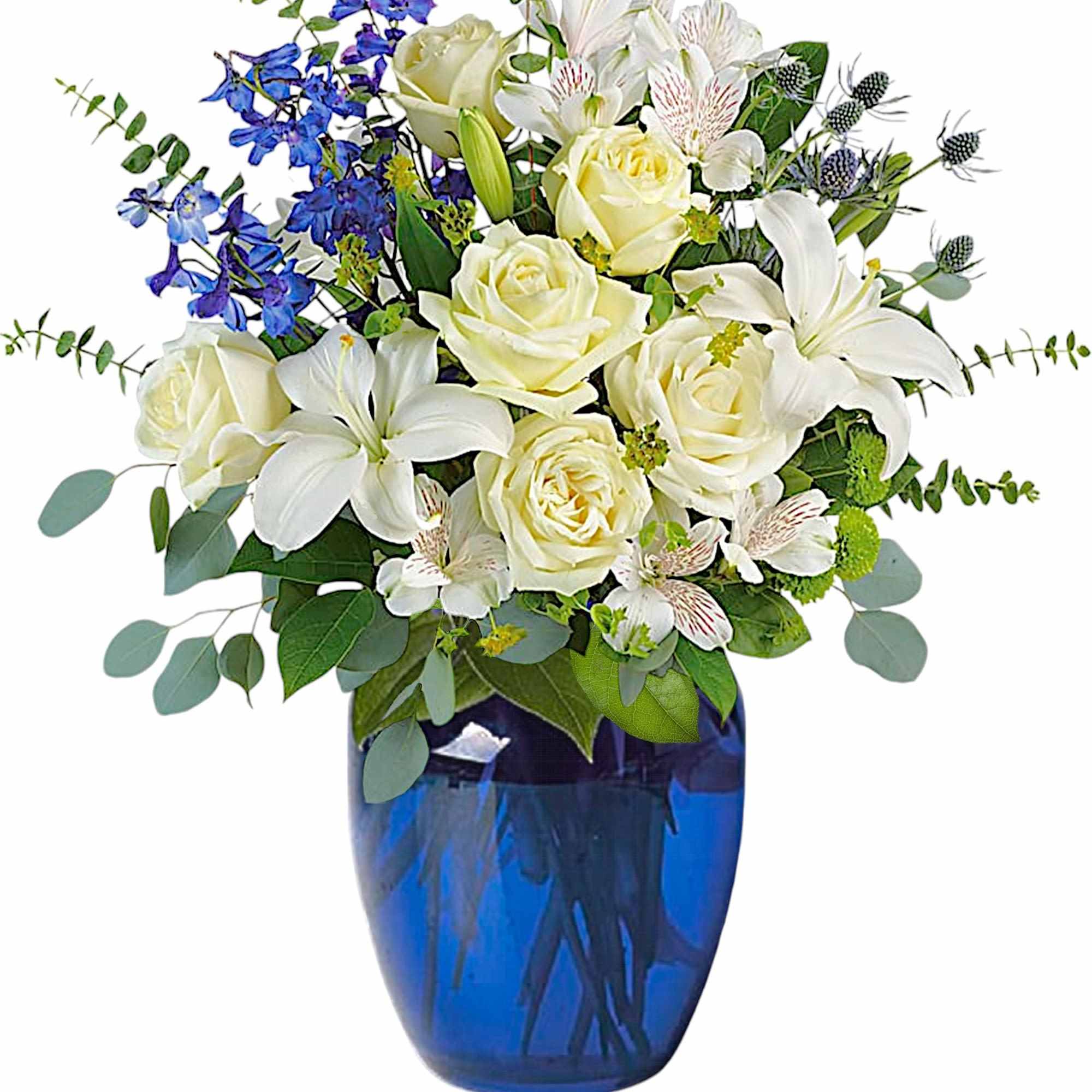 White roses and lilies in a blue glass vase with blue flowers