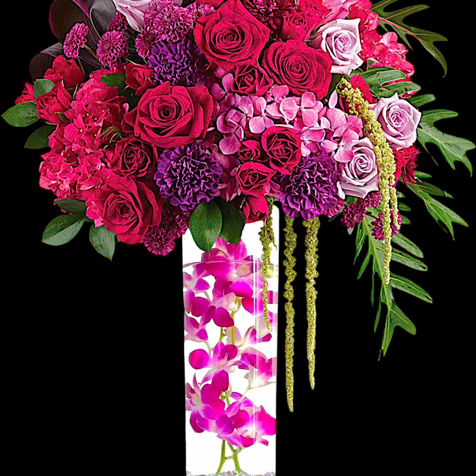 Pink and lavender rose arrangement in a tall glass vase with orchids
