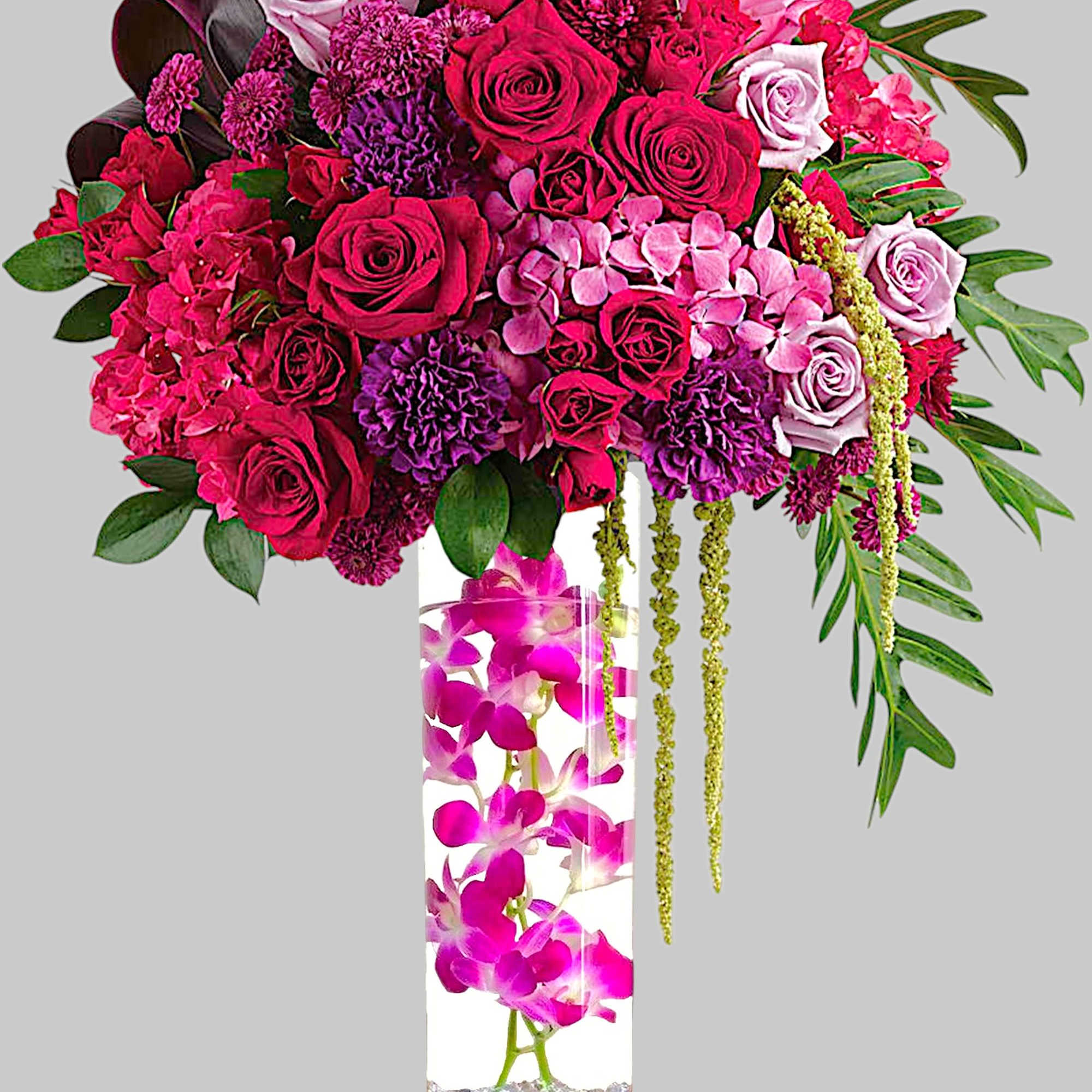 Pink and purple floral arrangement in a tall glass vase