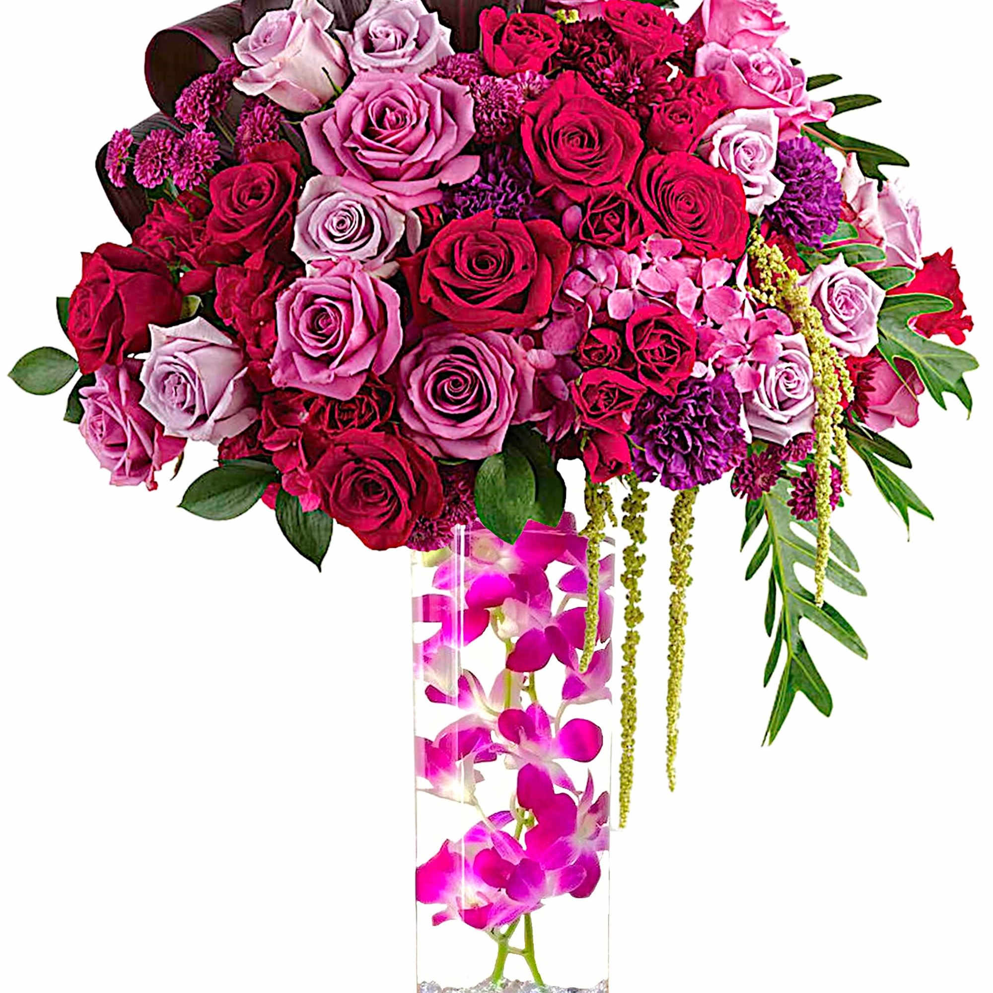 Large pink and red rose arrangement in a tall clear vase with orchids