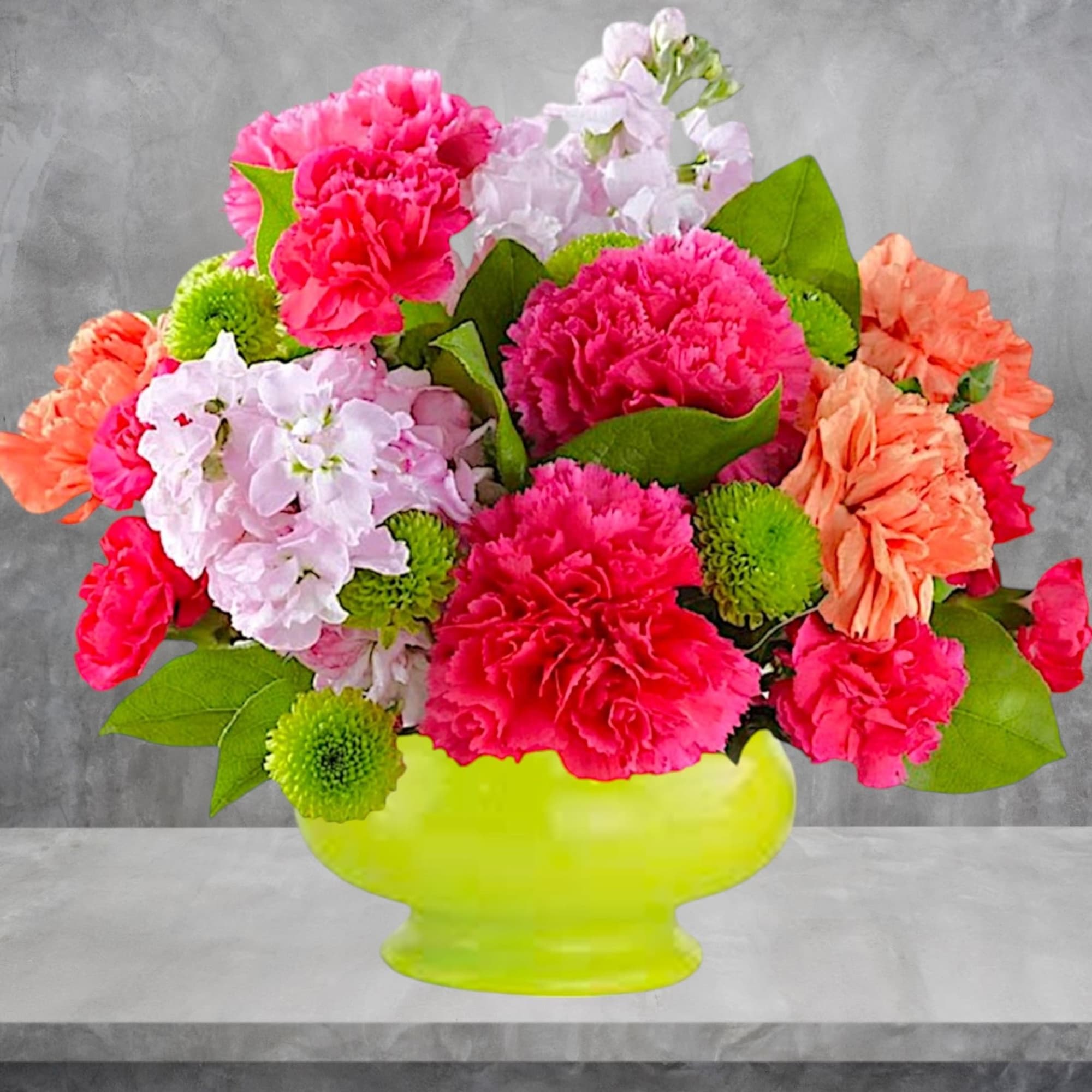 Bright mixed bouquet in a lime green vase with pink, peach, and white flowers
