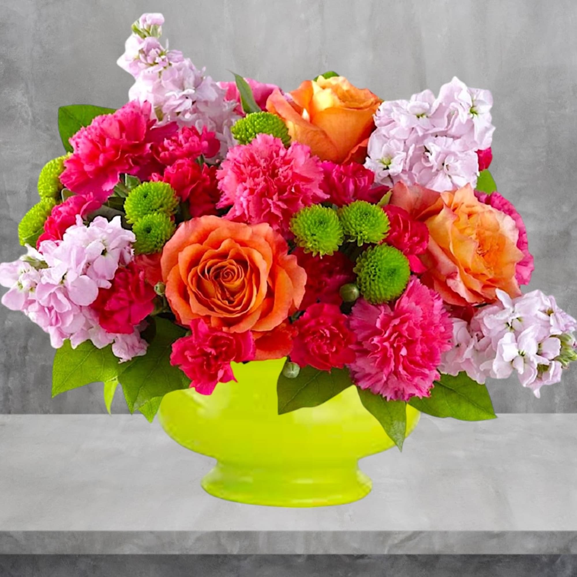 Bright mixed bouquet in a lime green vase with orange and pink flowers