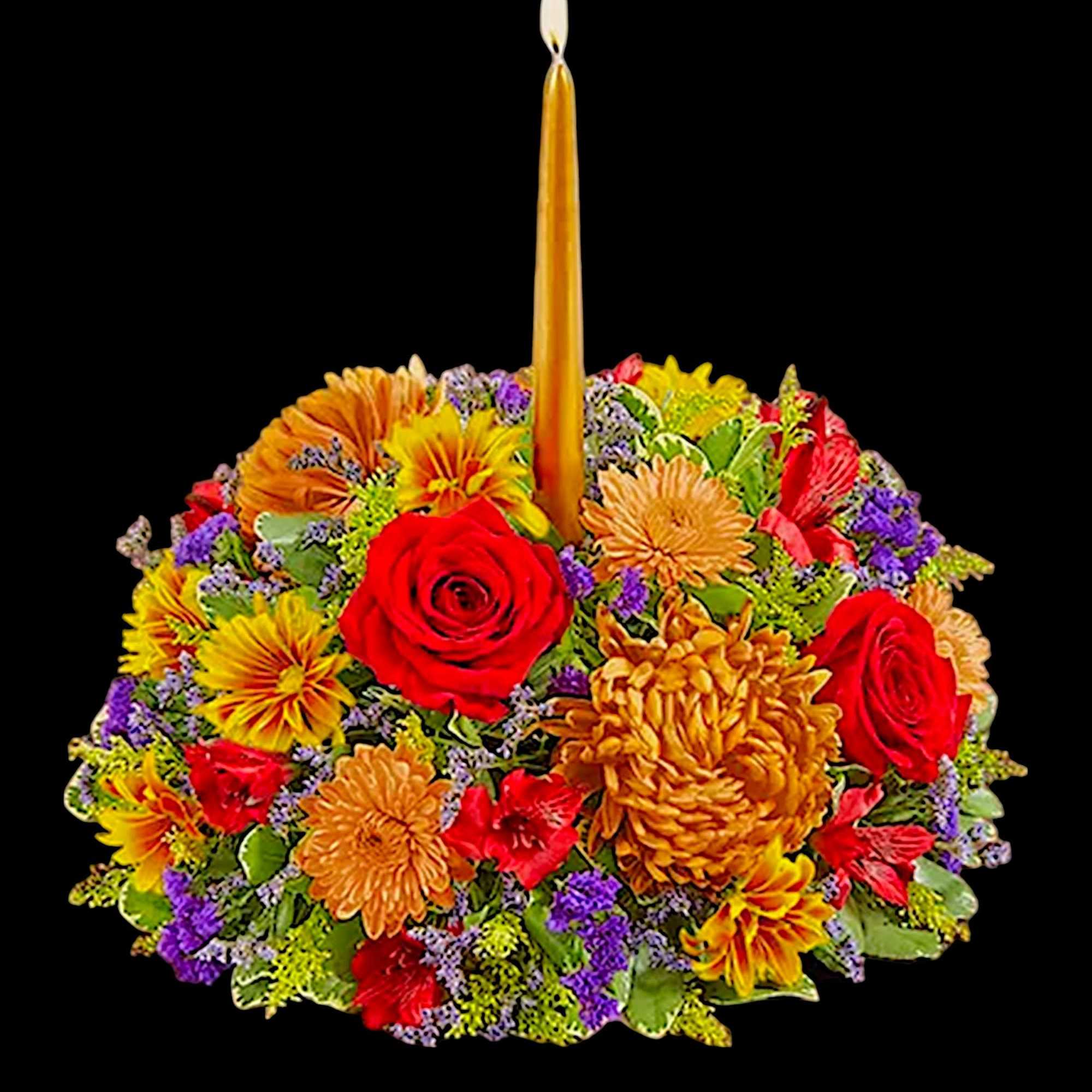 Round floral arrangement with a tall candle in the center