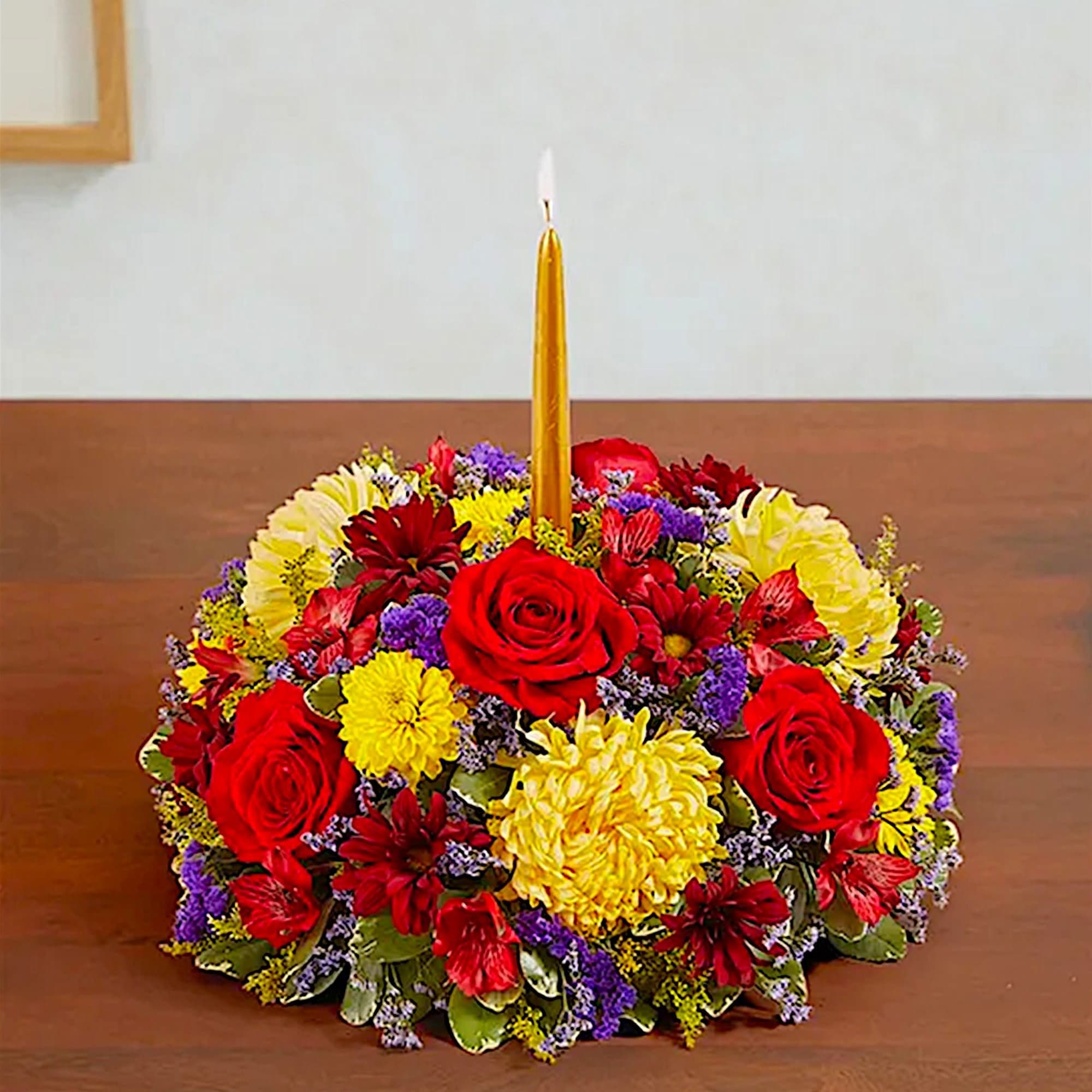 Round floral centerpiece with a tall gold candle in the middle, photo 2 of 7