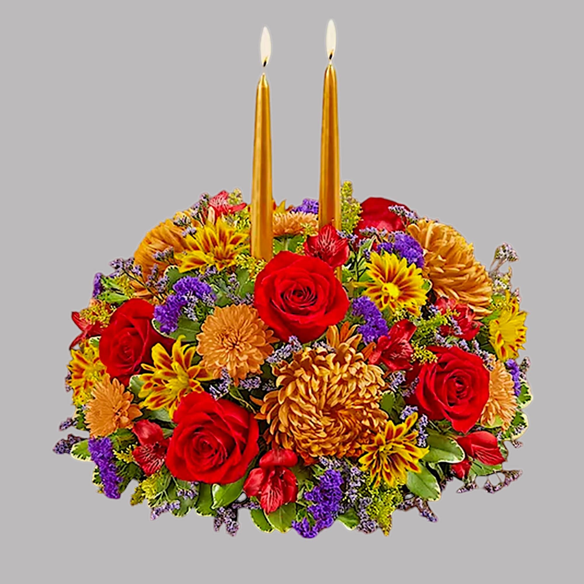 Colorful floral centerpiece with two gold taper candles