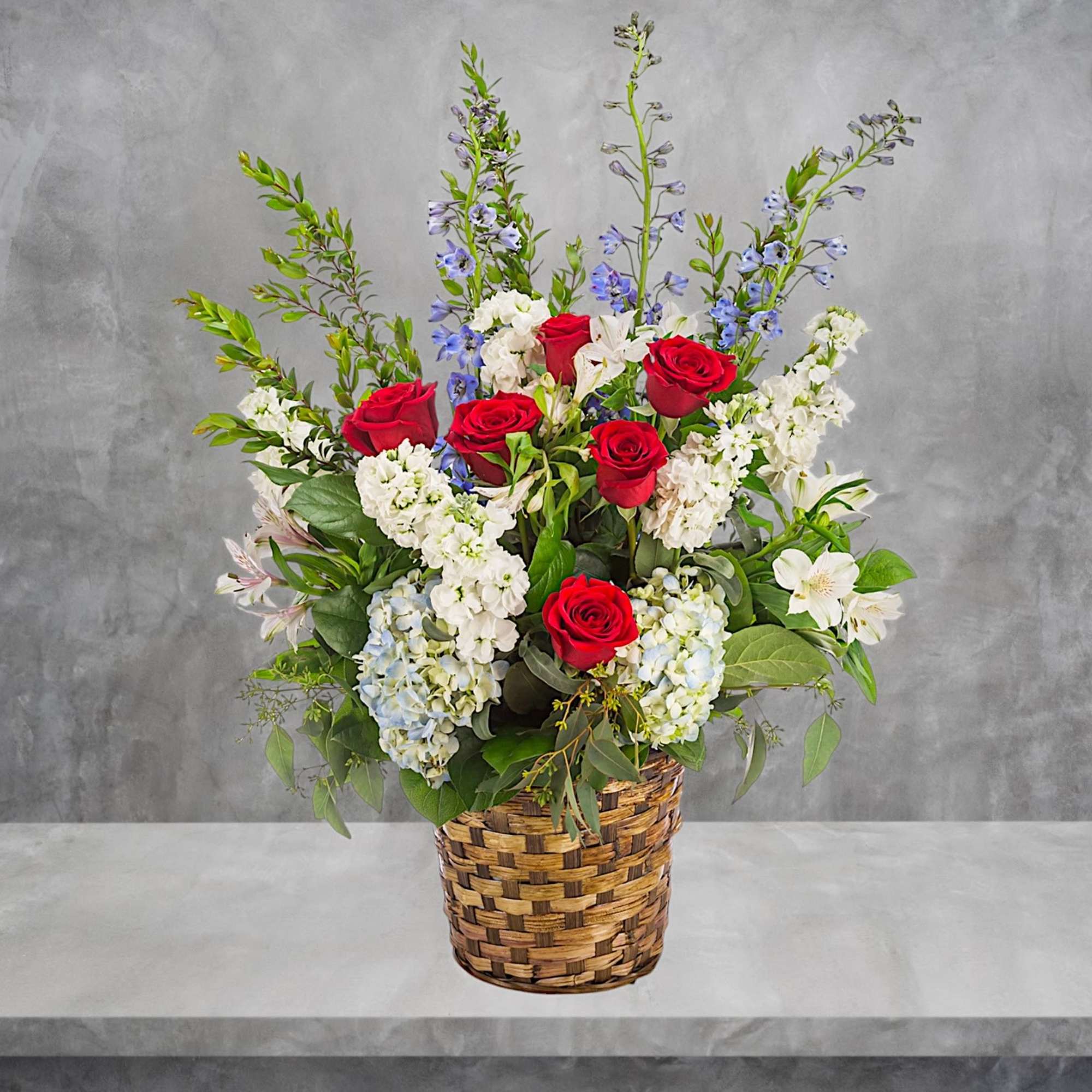 A red, white, and blue tribute flower basket featuring red roses, blue, photo 3 of 5