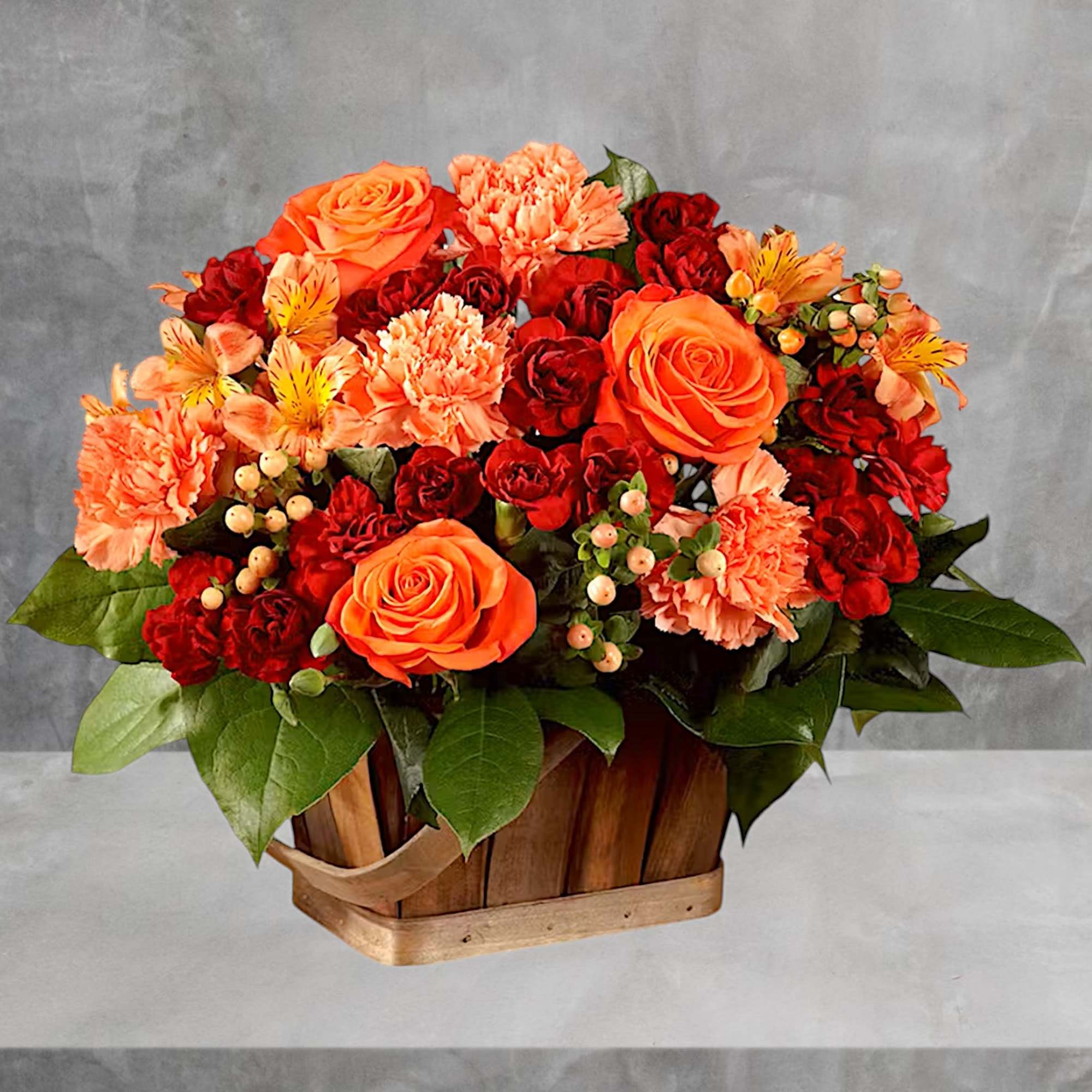 Orange and red flower arrangement in a wooden basket, photo 2 of 2