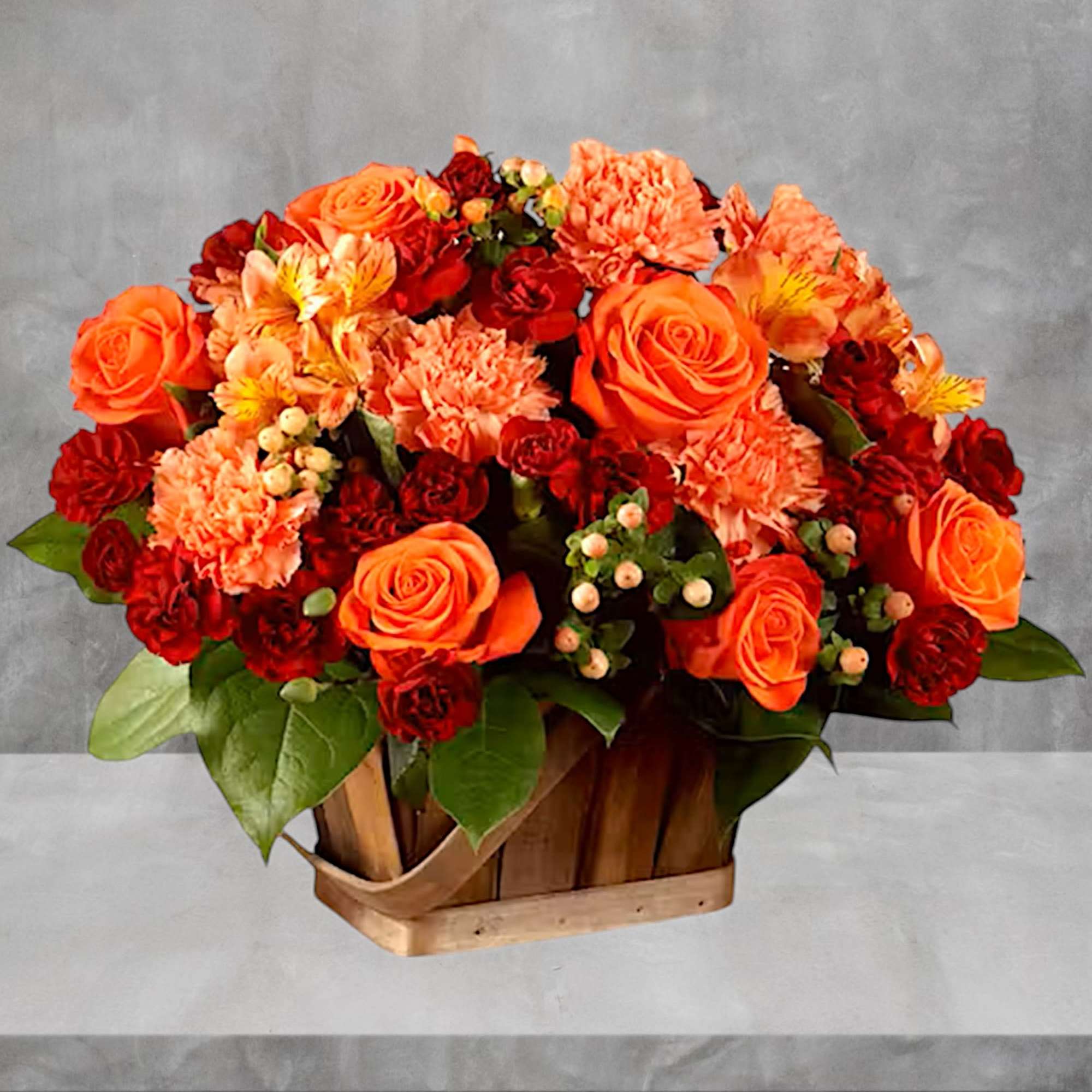 Orange and red flowers arranged in a wooden basket