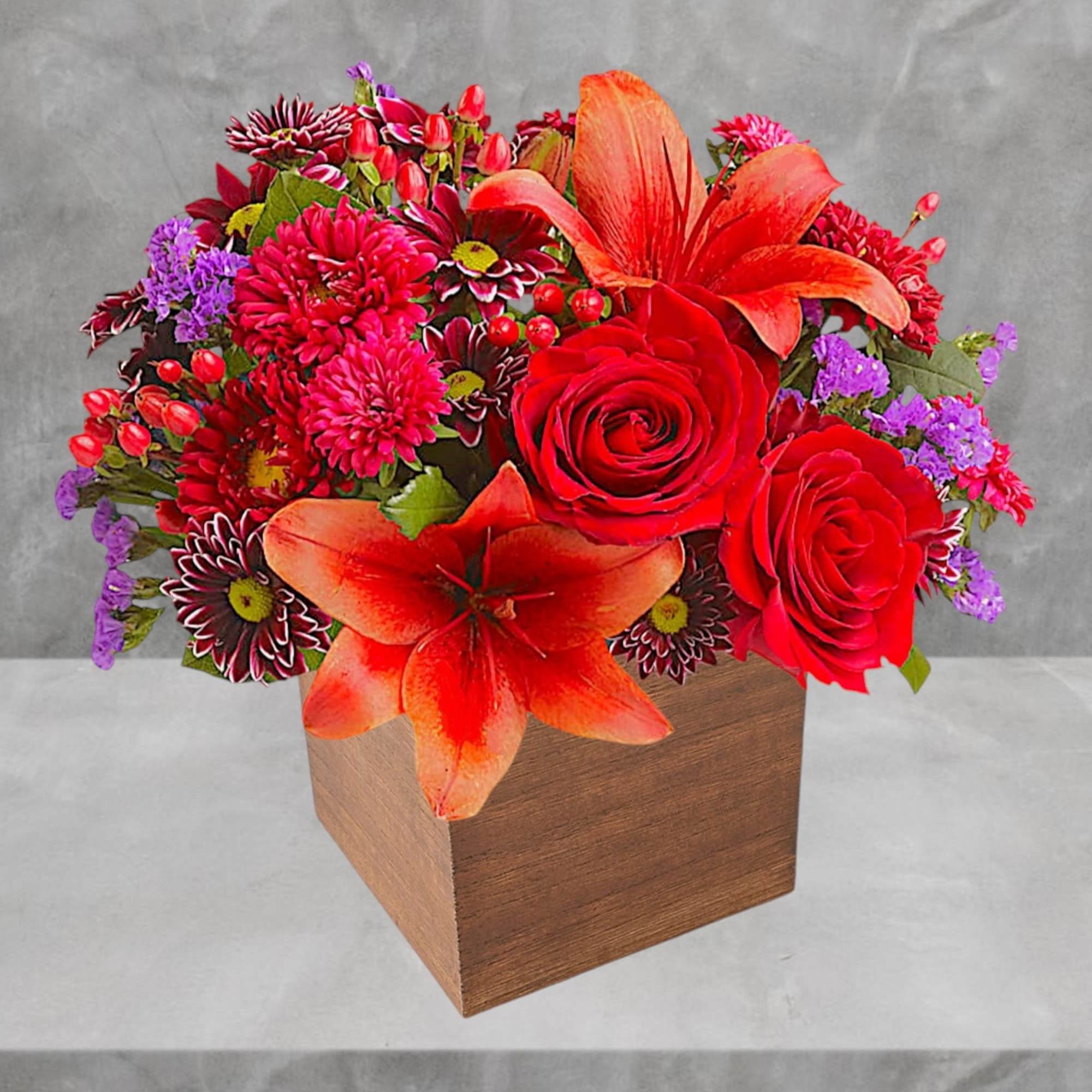 Bright red and orange flower arrangement in a wooden box