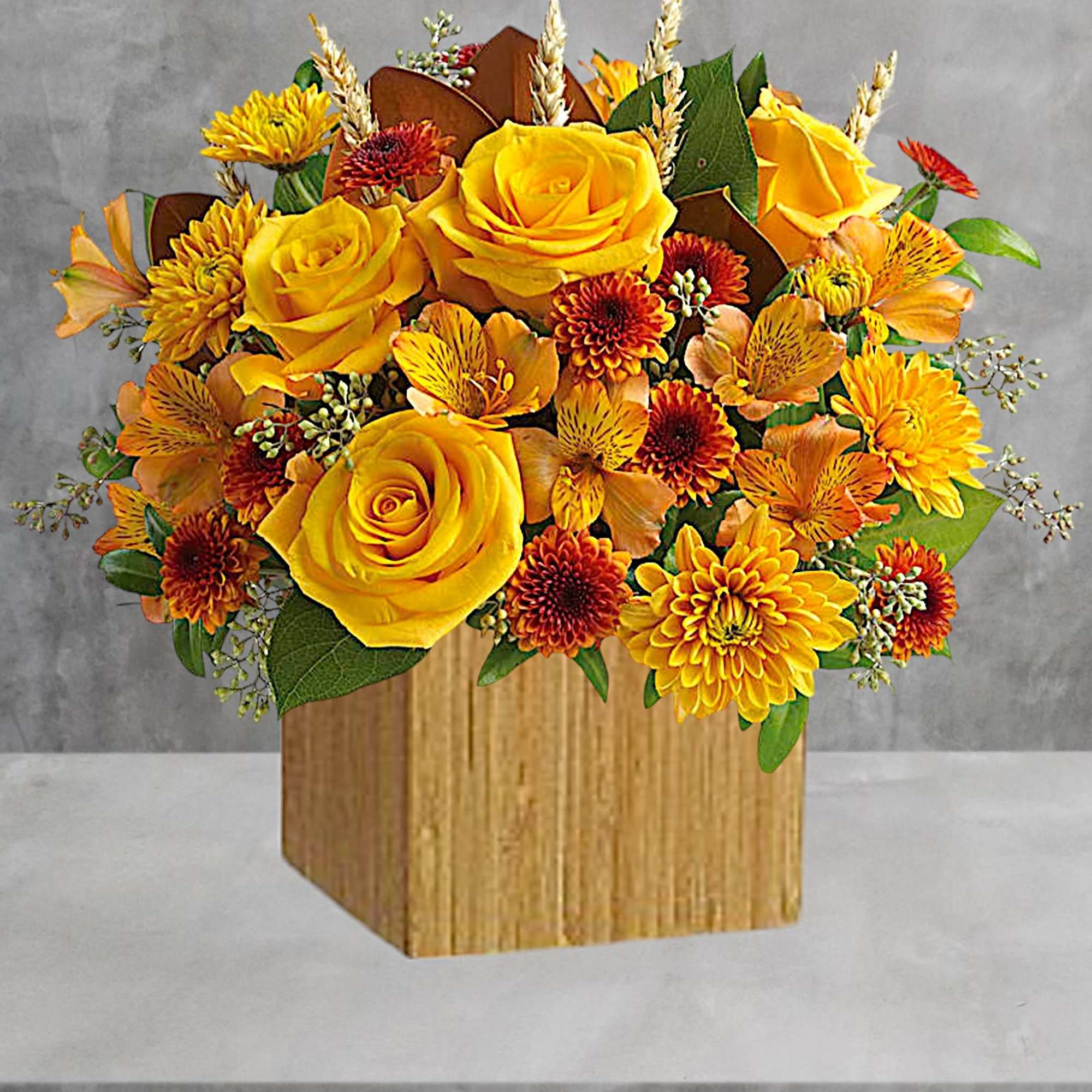 Yellow roses and orange chrysanthemums in a wooden box
