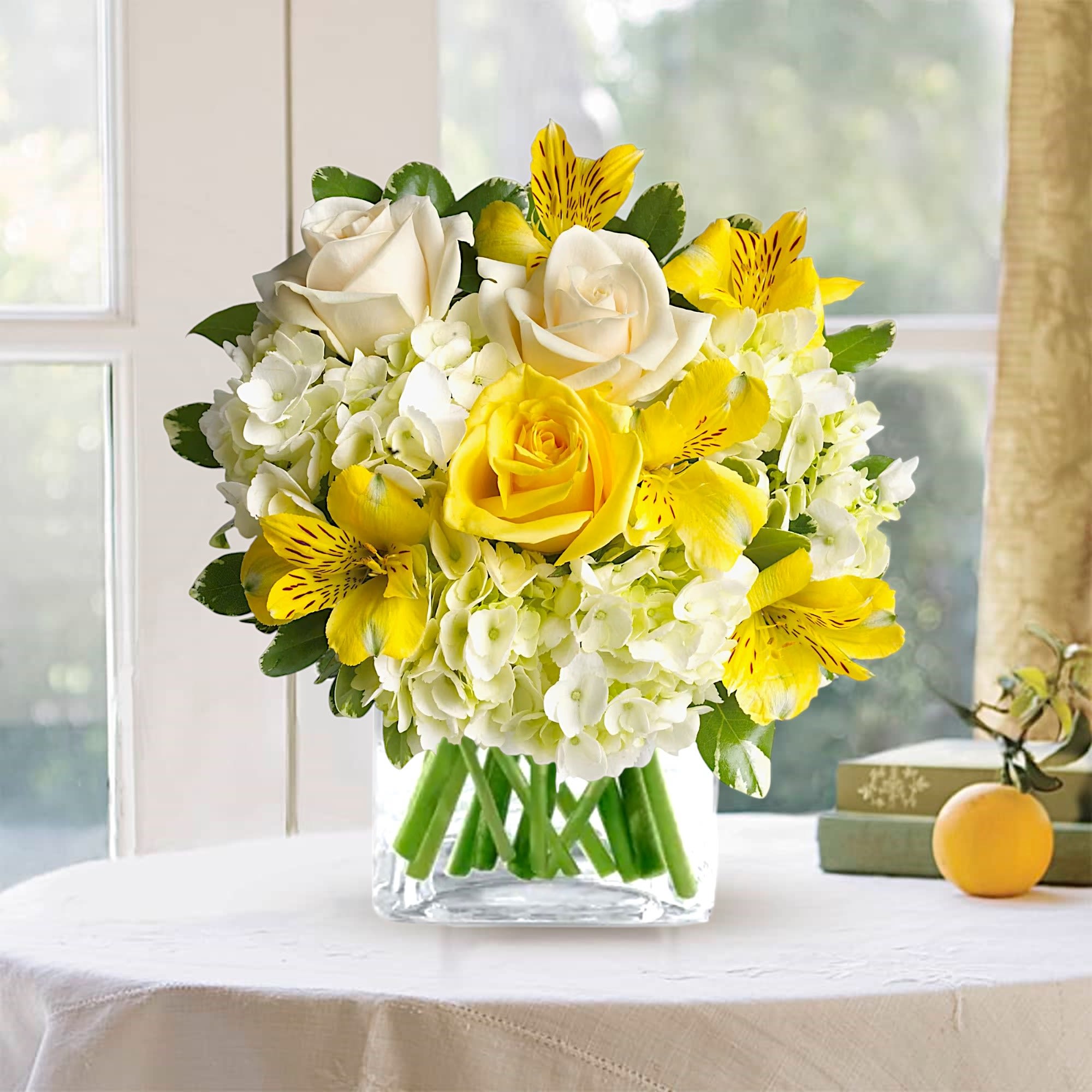 Yellow and white flower arrangement in a clear glass vase