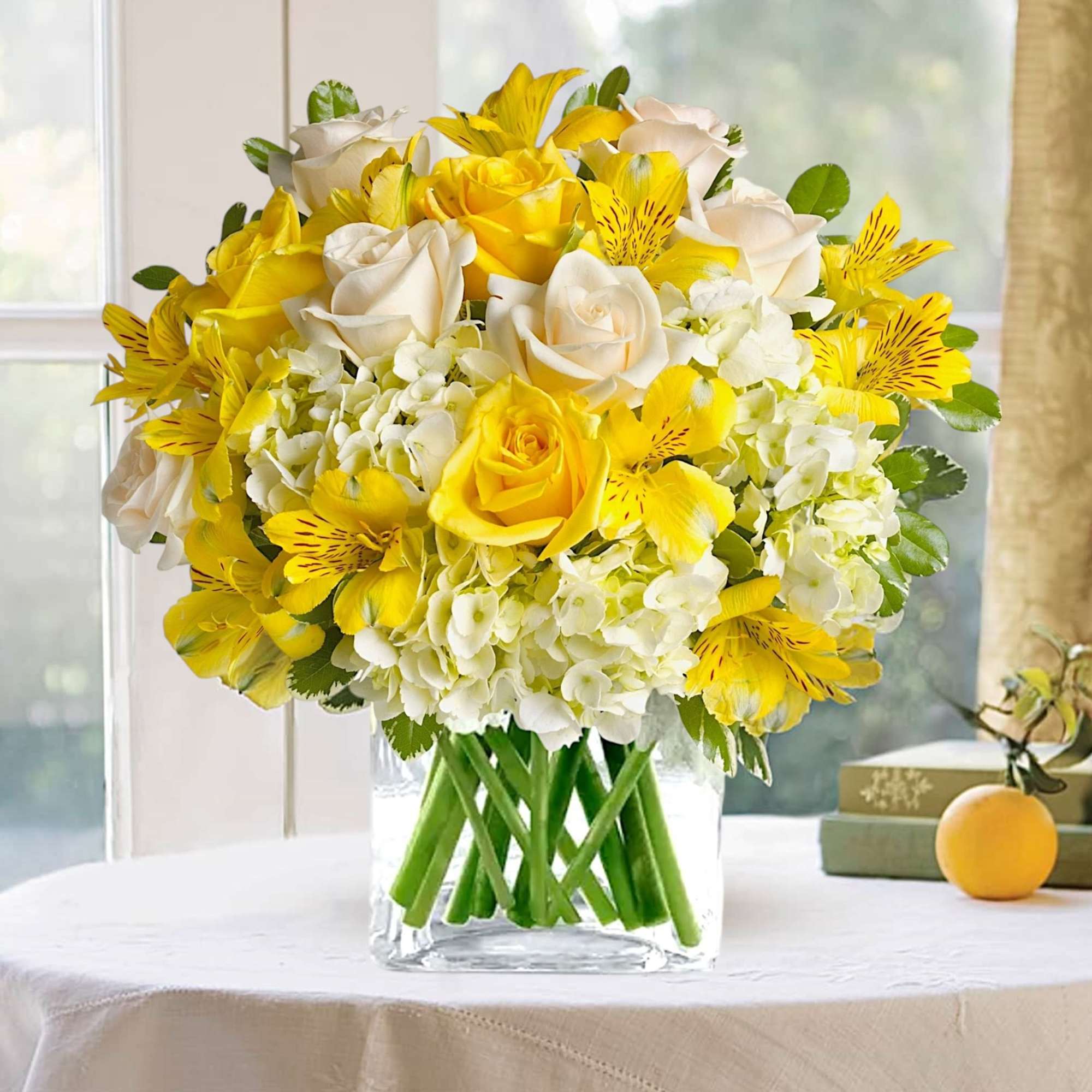 Yellow and white bouquet of roses and alstroemeria in a clear glass vase, photo 2 of 3