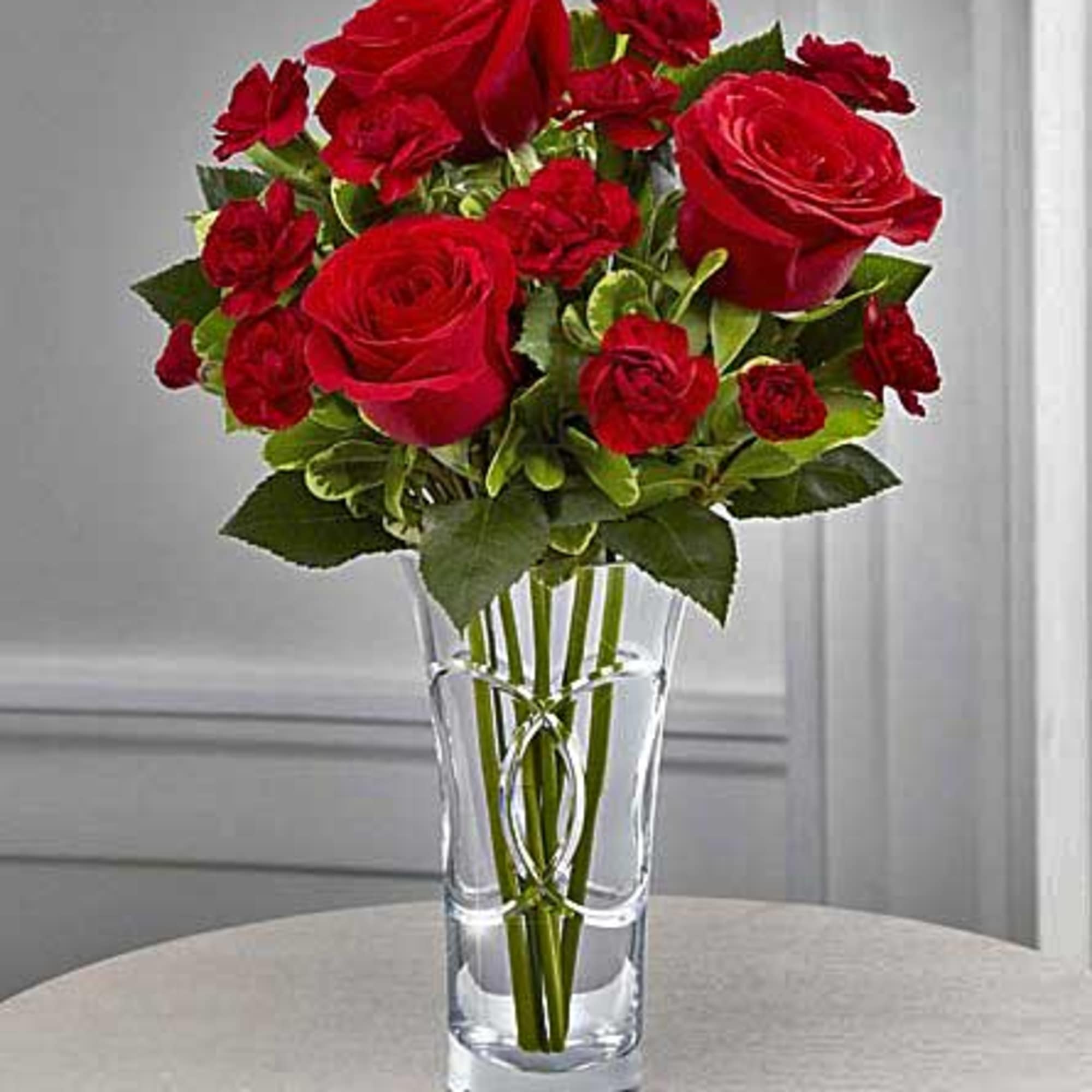 Red roses and carnations in a clear glass vase, photo 8 of 8