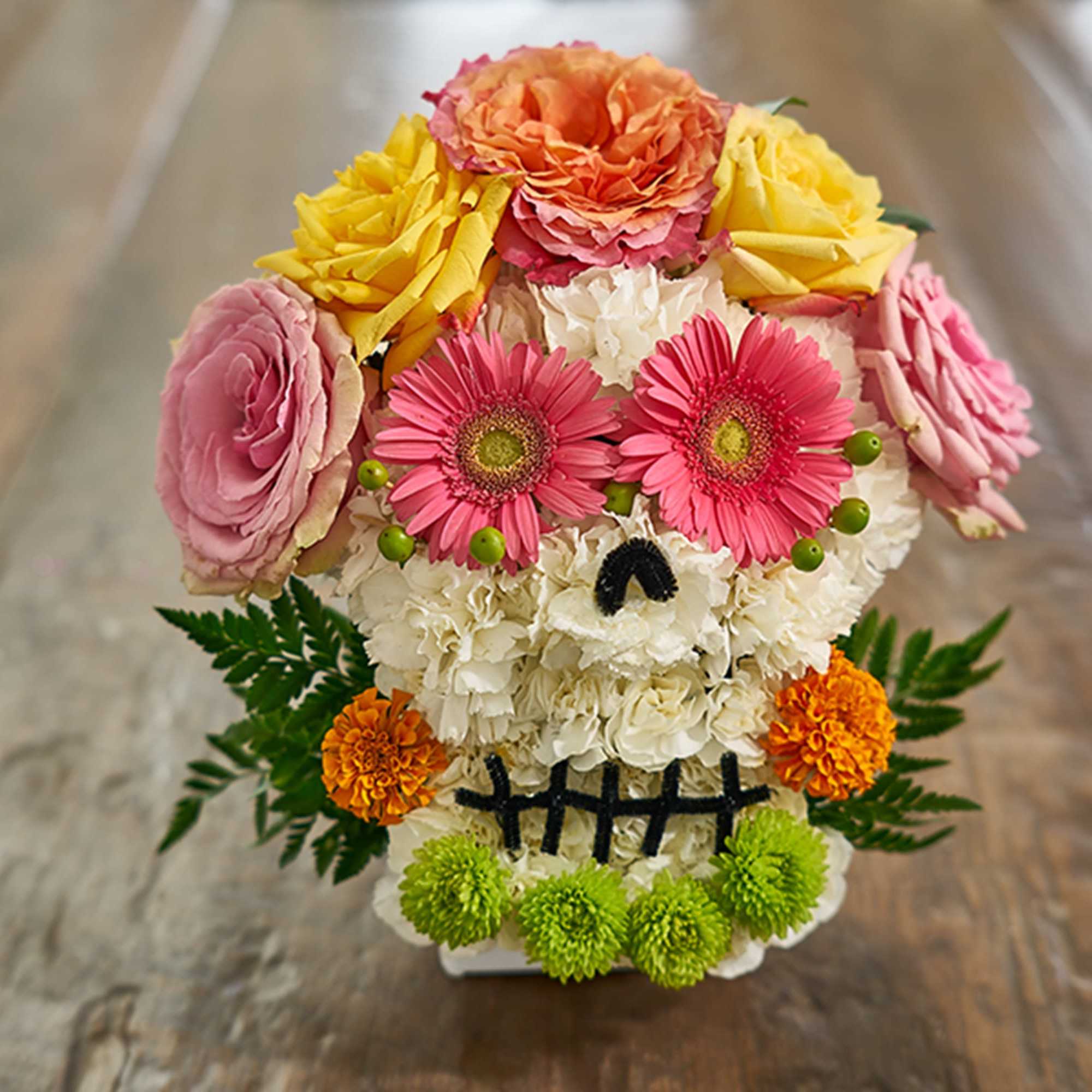 Skull-shaped floral arrangement with pink, yellow, orange, and white flowers
