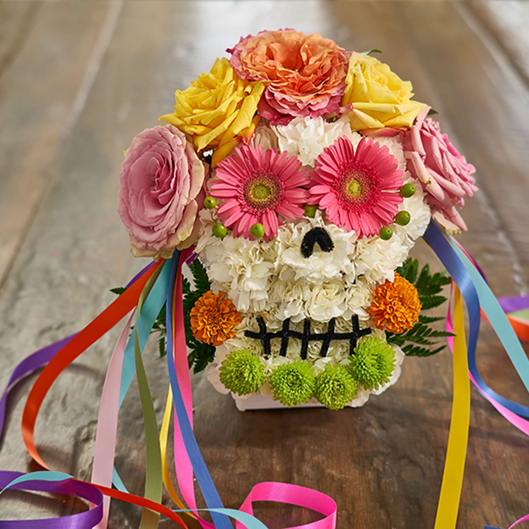 Flower arrangement shaped like a skull with colorful ribbon streamers