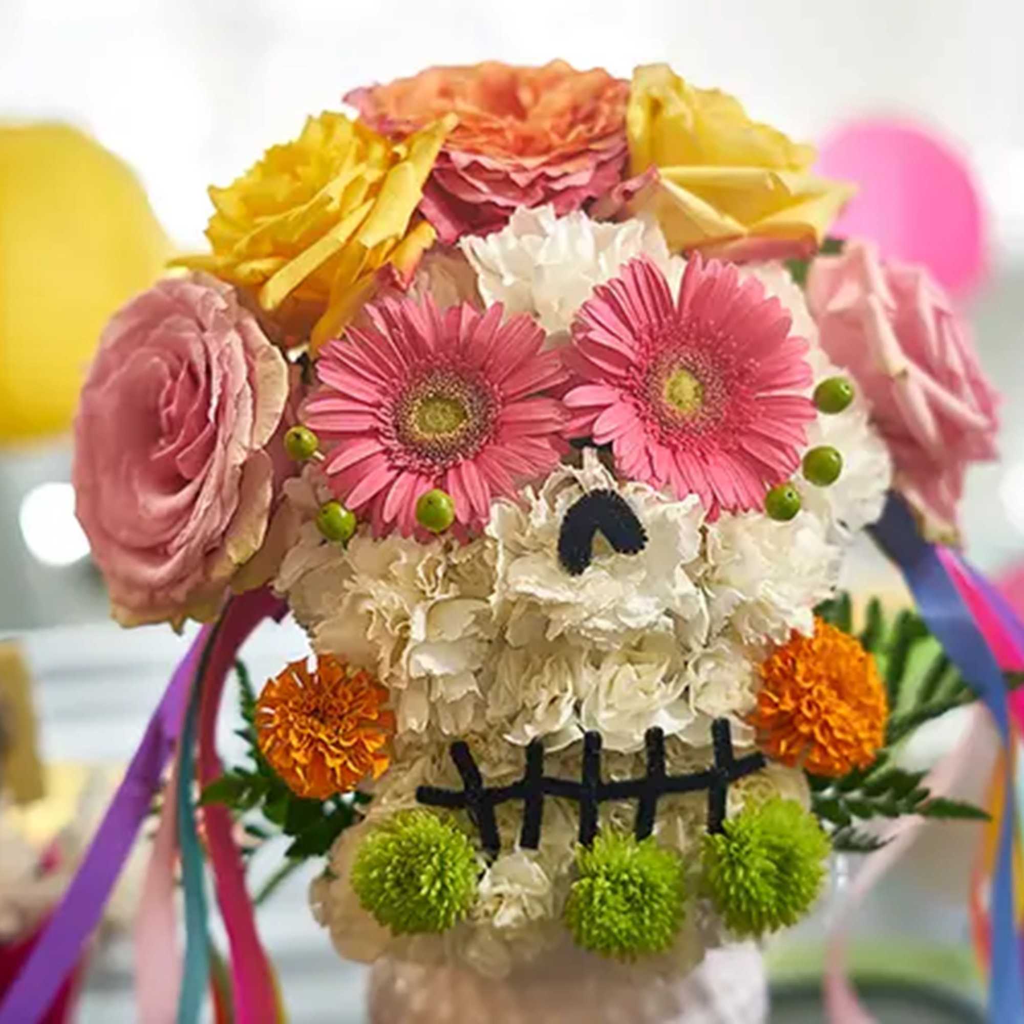 Flower arrangement shaped like a skull with pink and yellow blooms