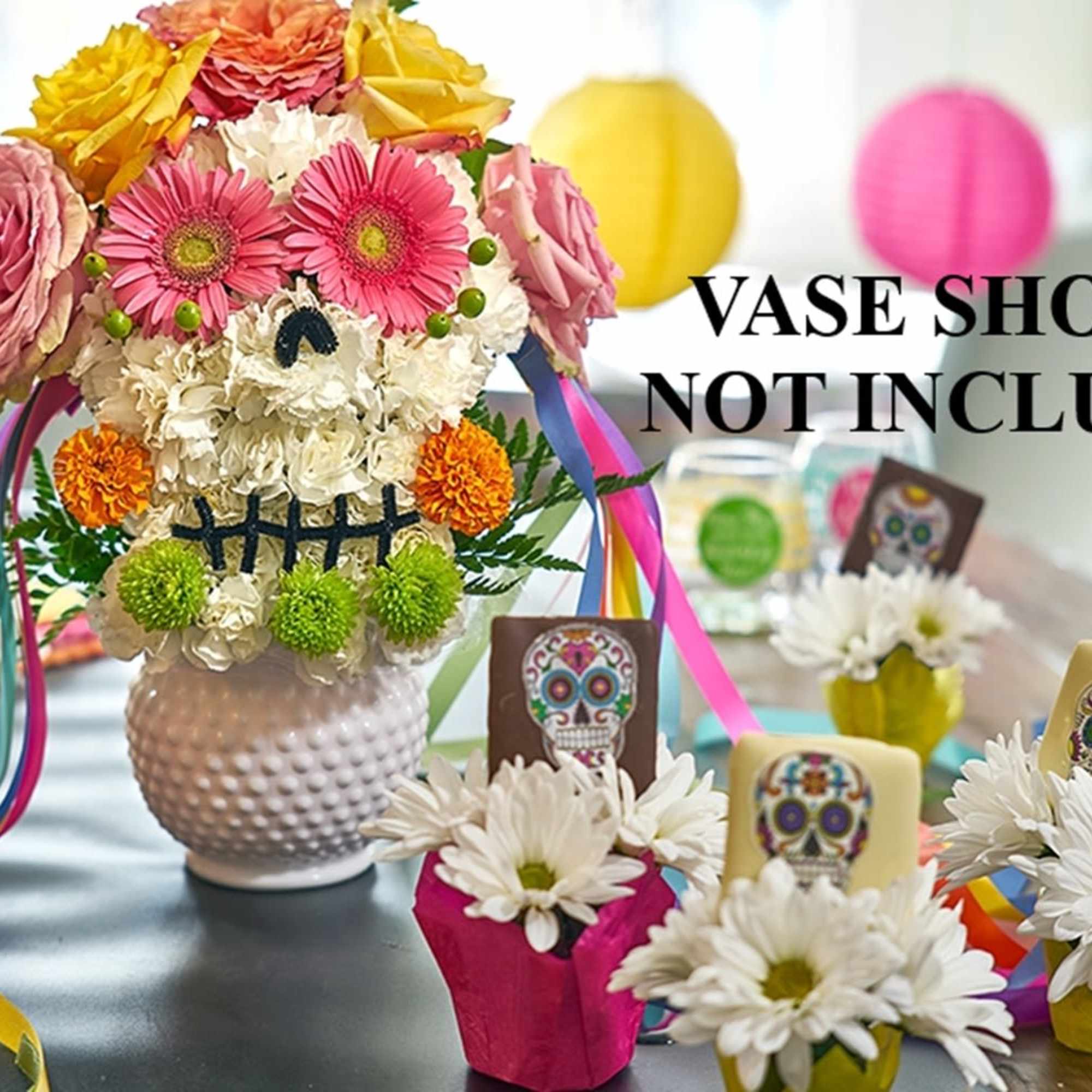 Colorful flower arrangement in a white vase with ribbon streamers