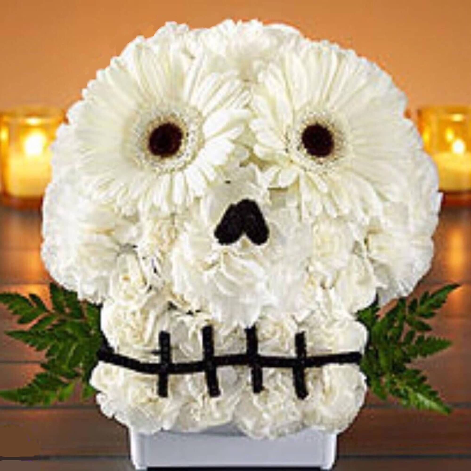 White flower arrangement shaped like a skull with dark eye and nose accents