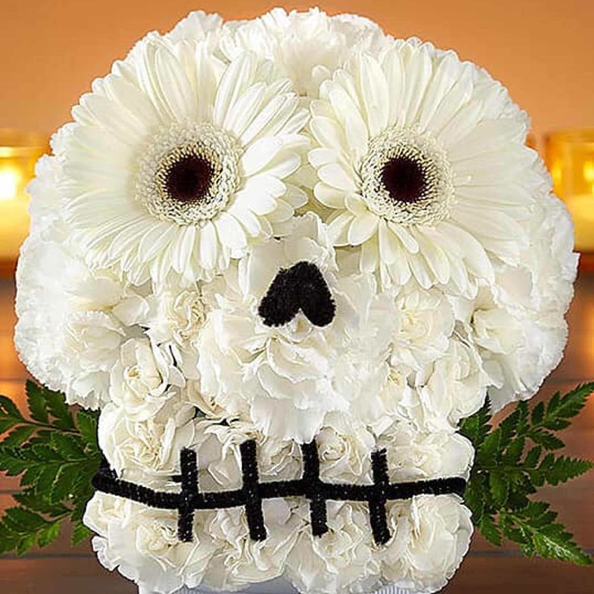 White floral arrangement shaped like a skull in a white container