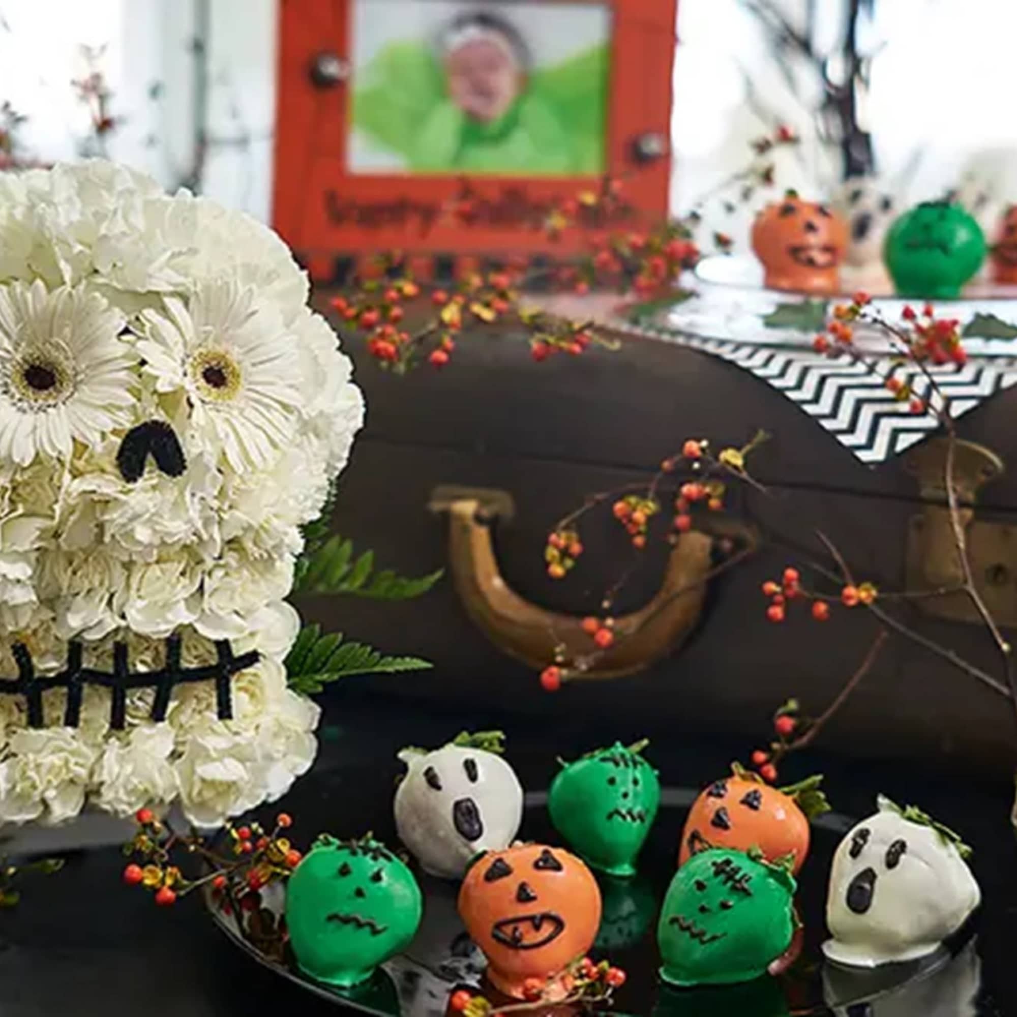 White flower skull decoration with Halloween treats and pumpkins