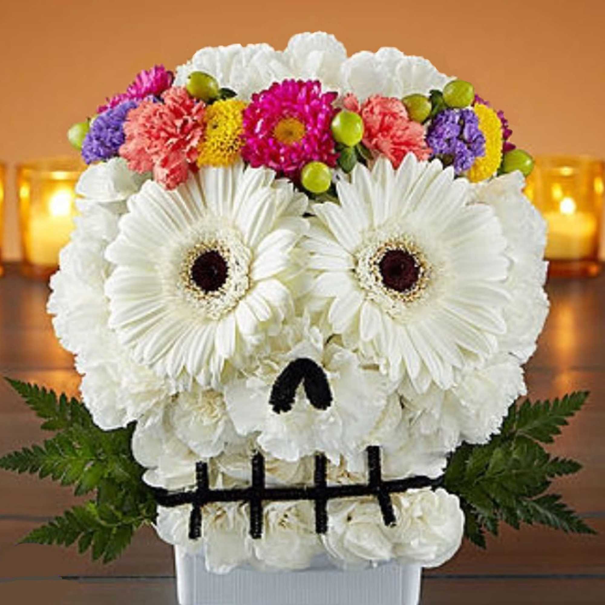White floral arrangement shaped like a skull with colorful flowers on top