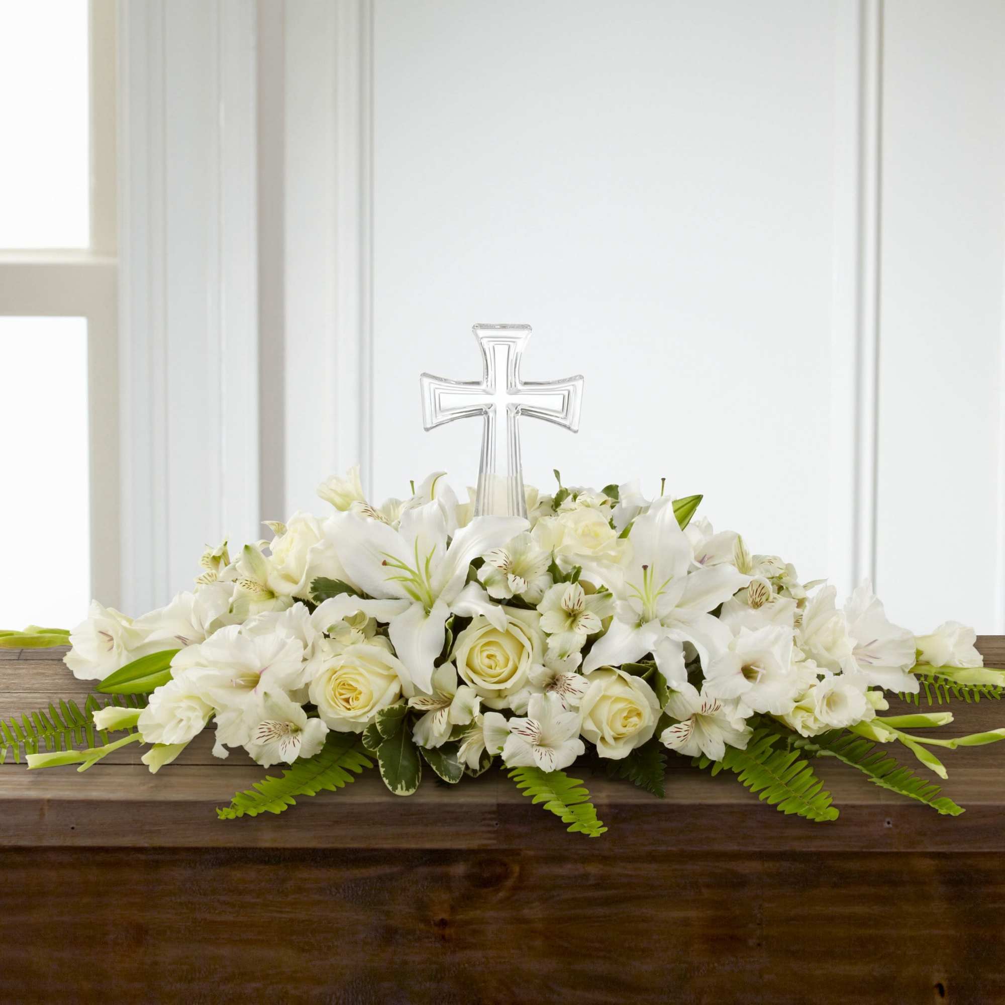 White floral casket spray with a clear cross centerpiece