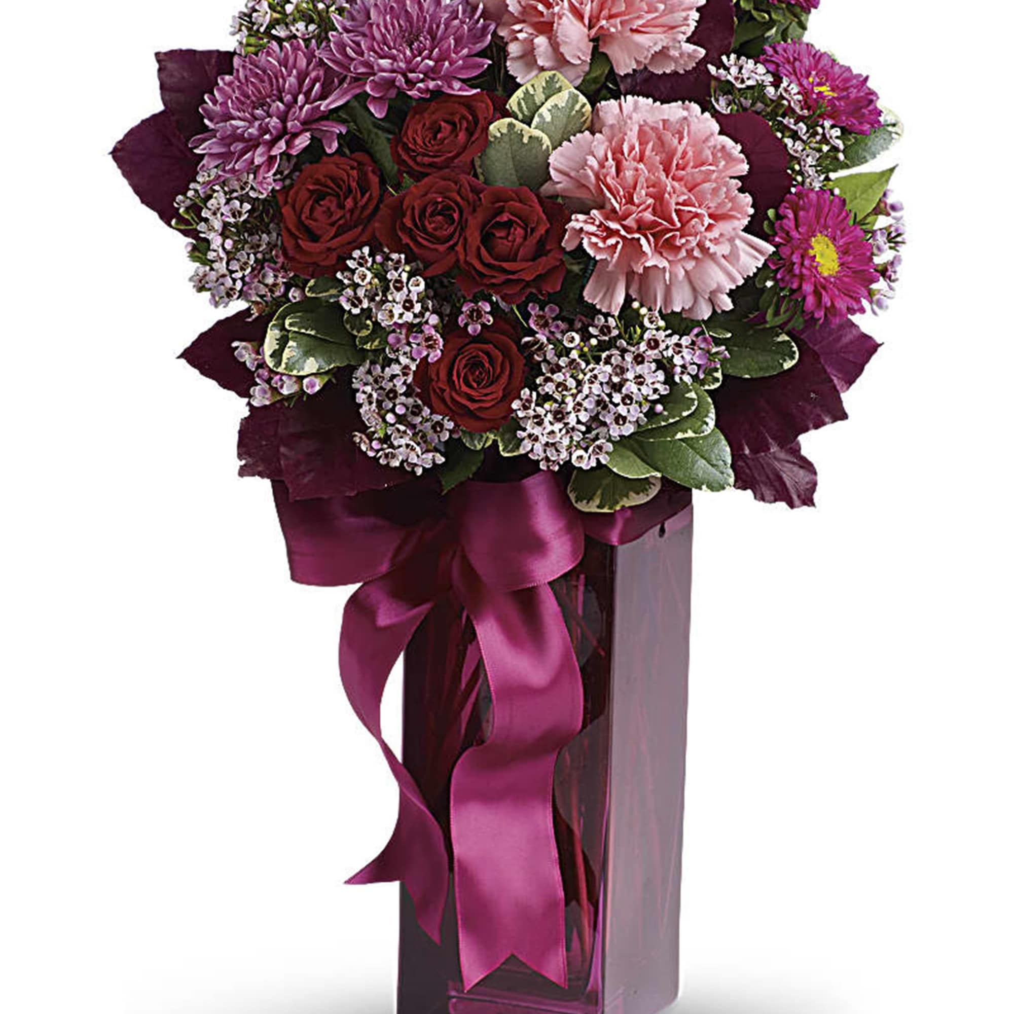 Bouquet of pink and red flowers in a tall glass vase with a ribbon