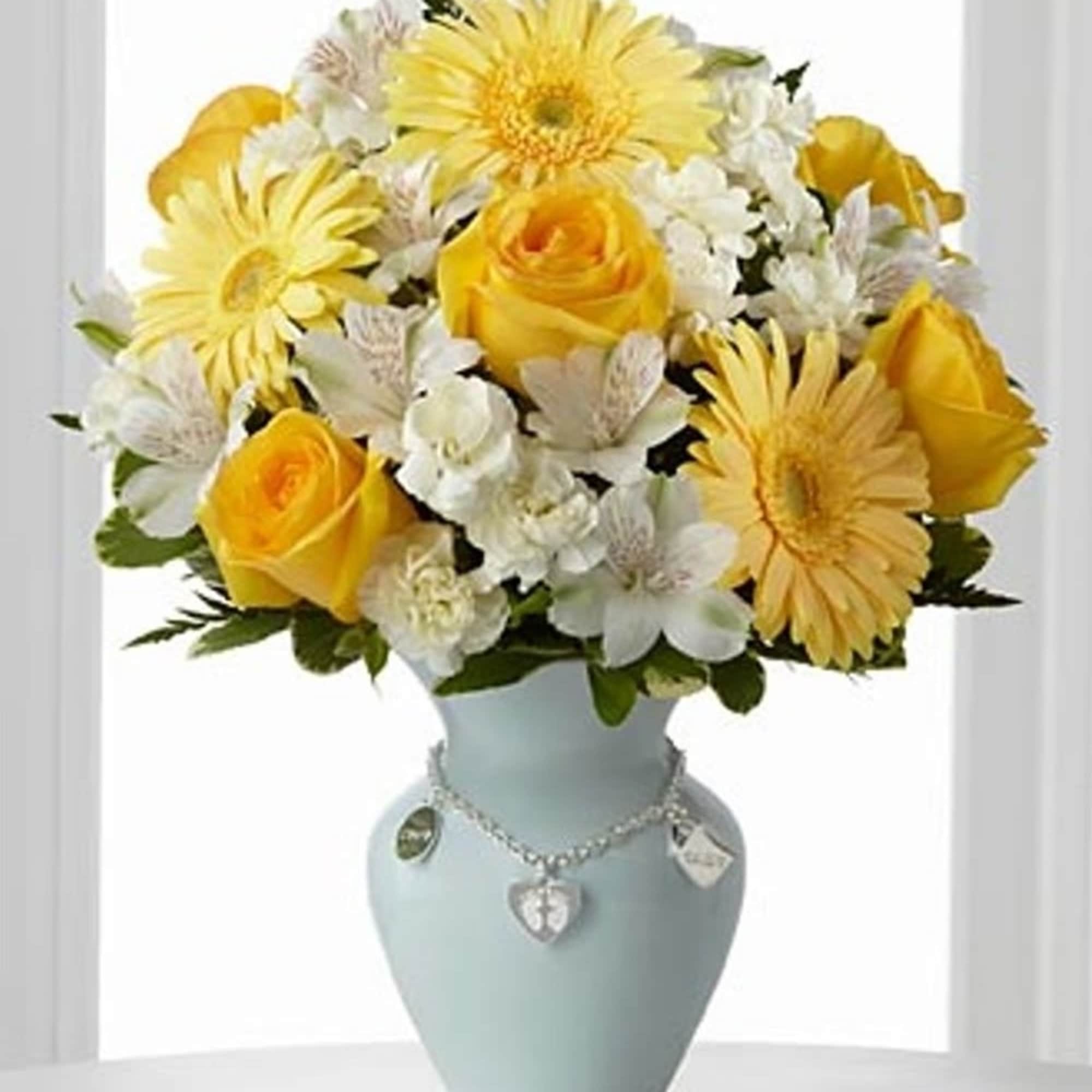 Yellow roses and daisies arranged in a pale blue vase