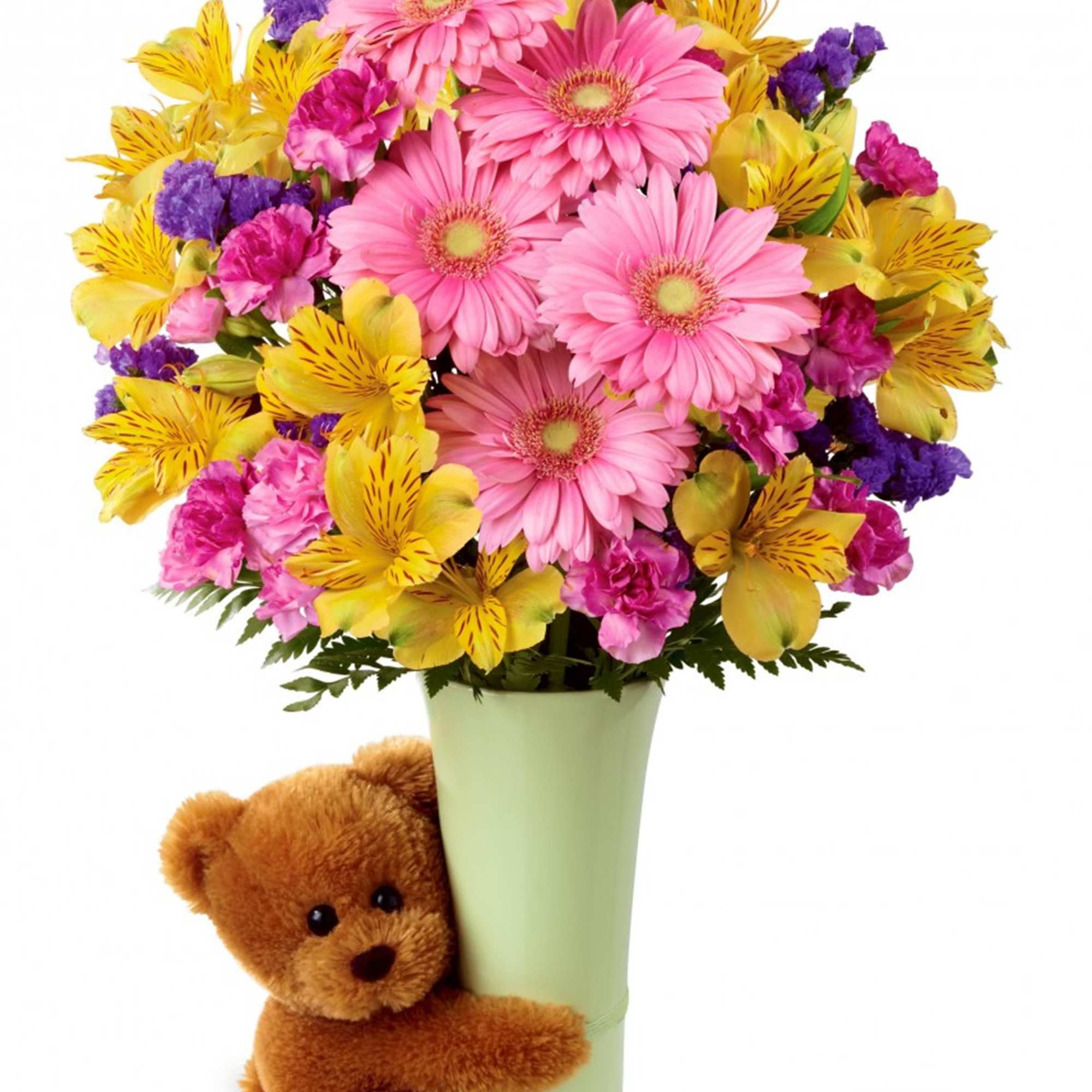Pink and yellow mixed bouquet in a green vase with a teddy bear