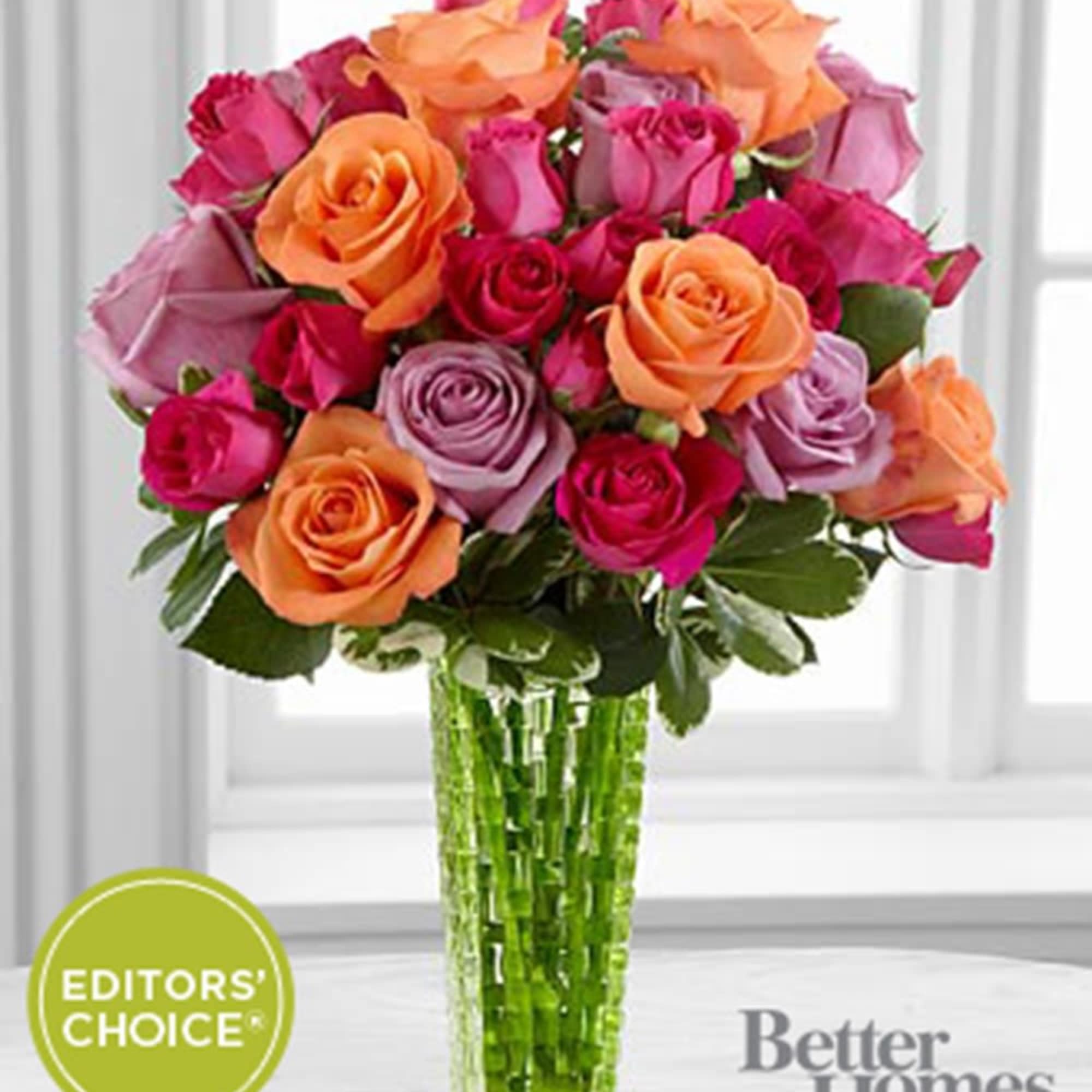 Bouquet of multicolored roses in a tall glass vase