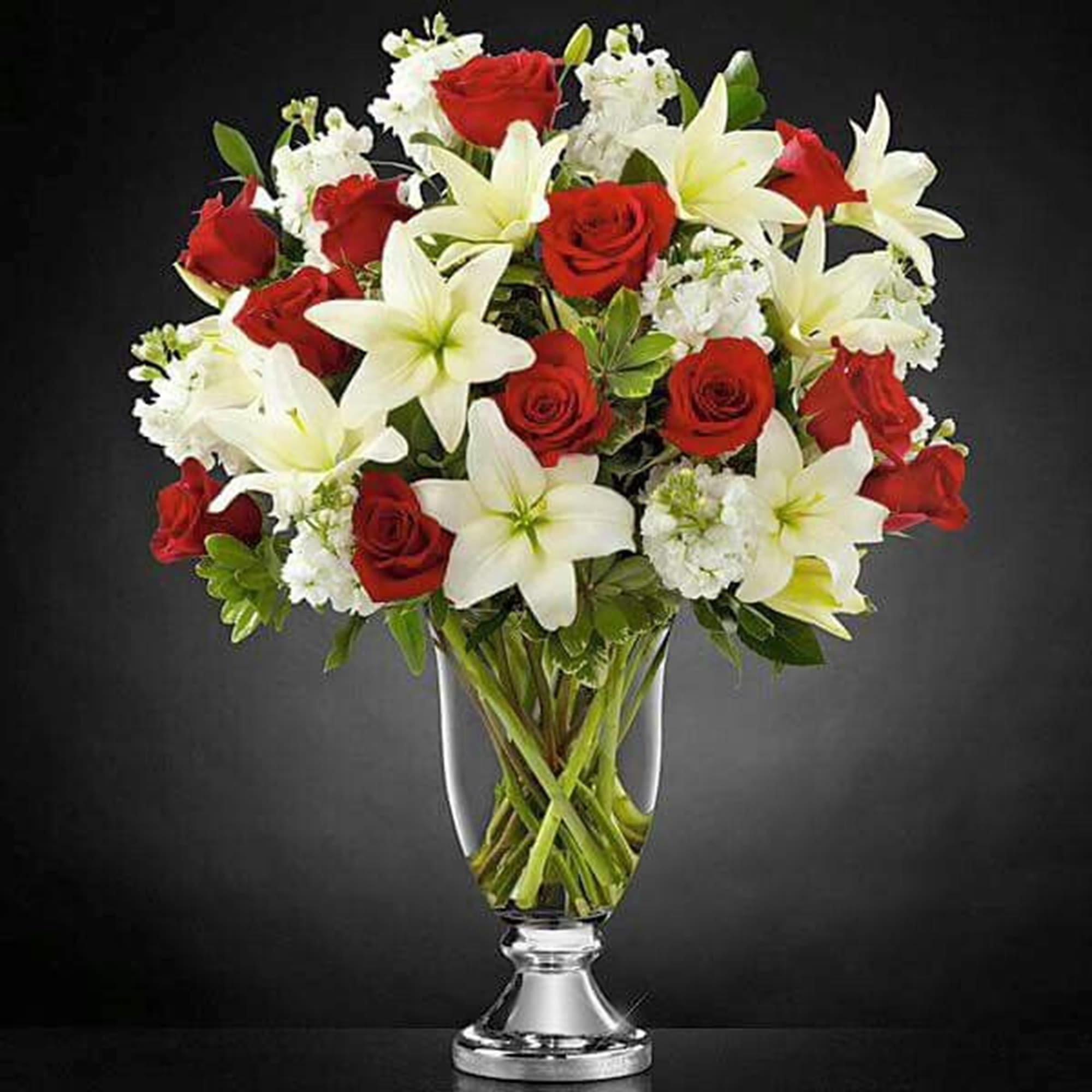 Red roses and white lilies in a clear glass vase