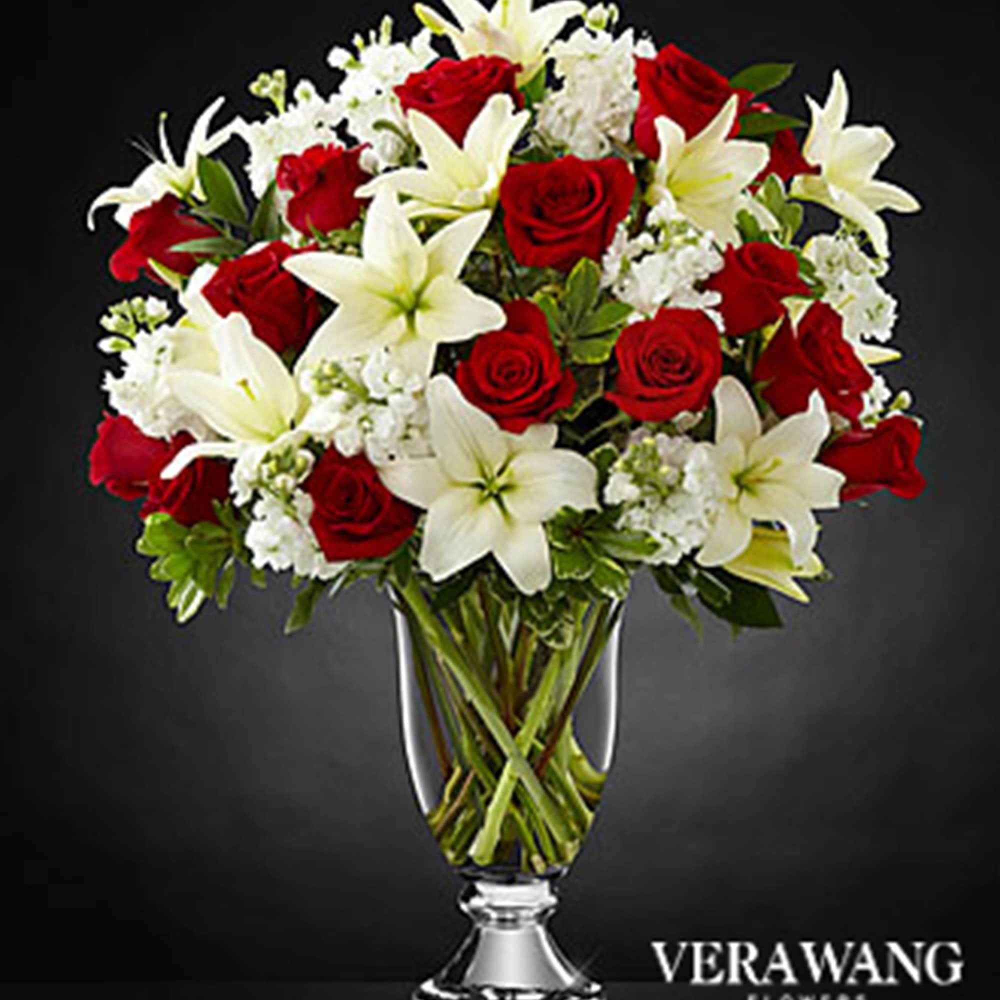 Red roses and white lilies arranged in a clear glass vase