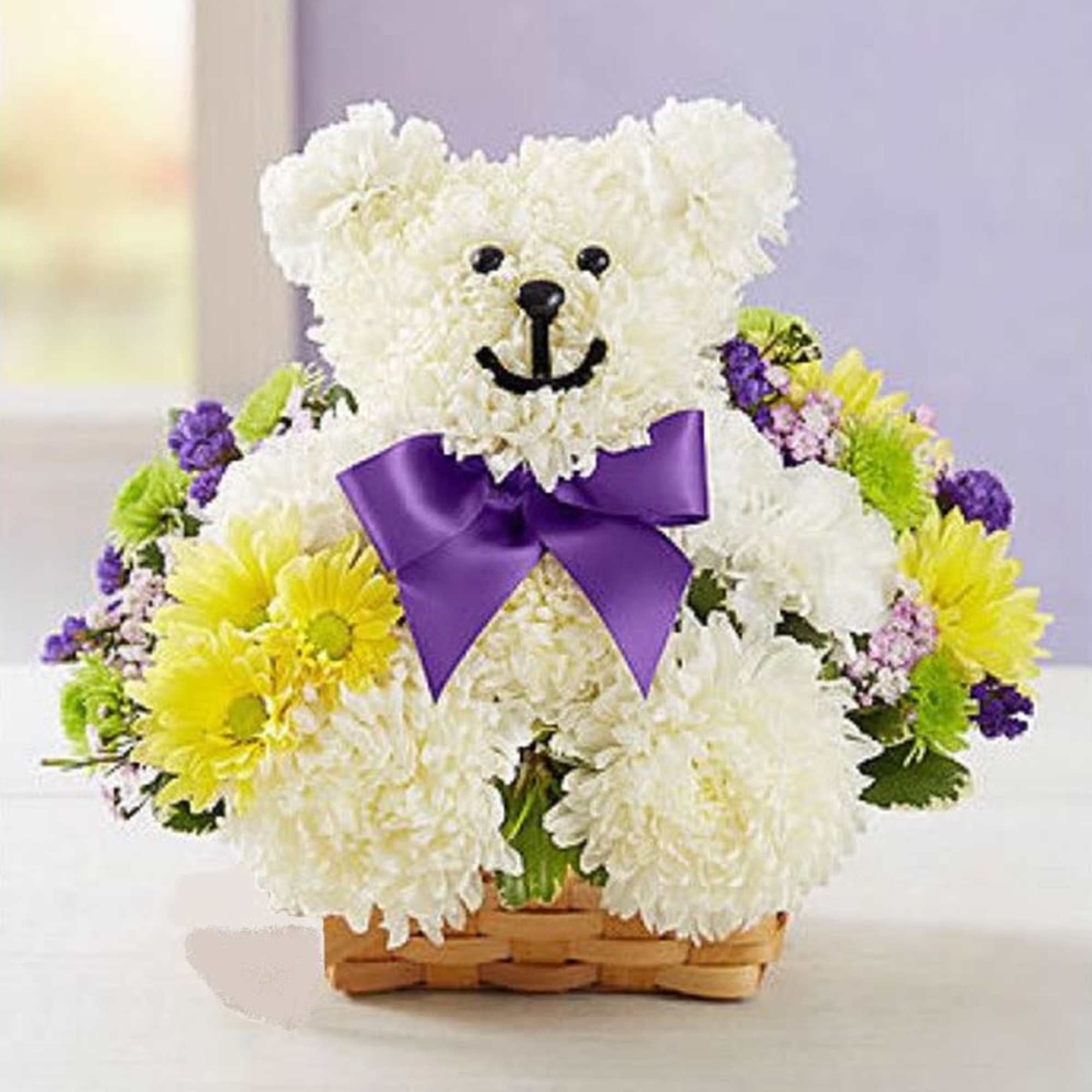 White teddy bear made of flowers with a purple bow in a basket