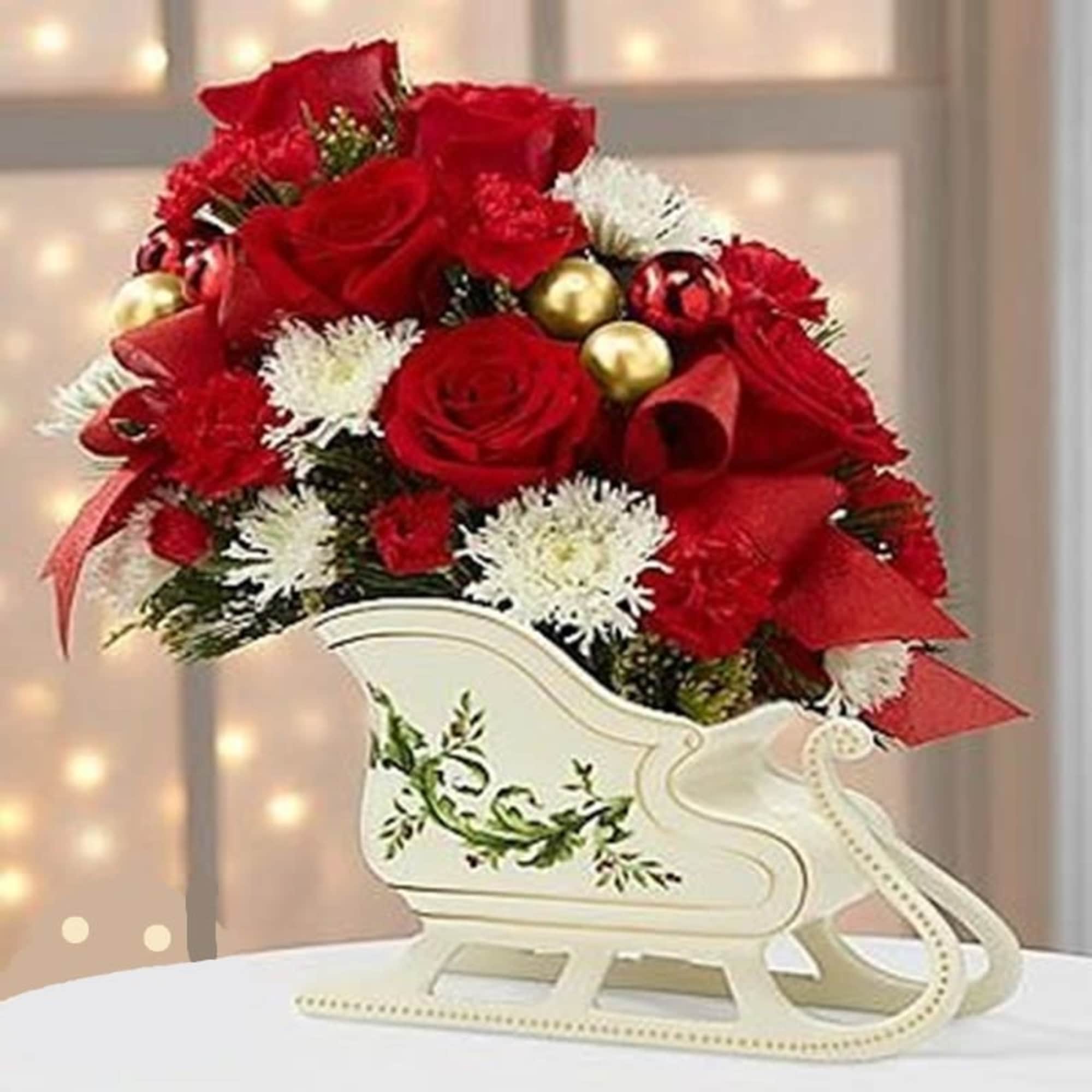 Red roses and white flowers arranged in a decorative sleigh