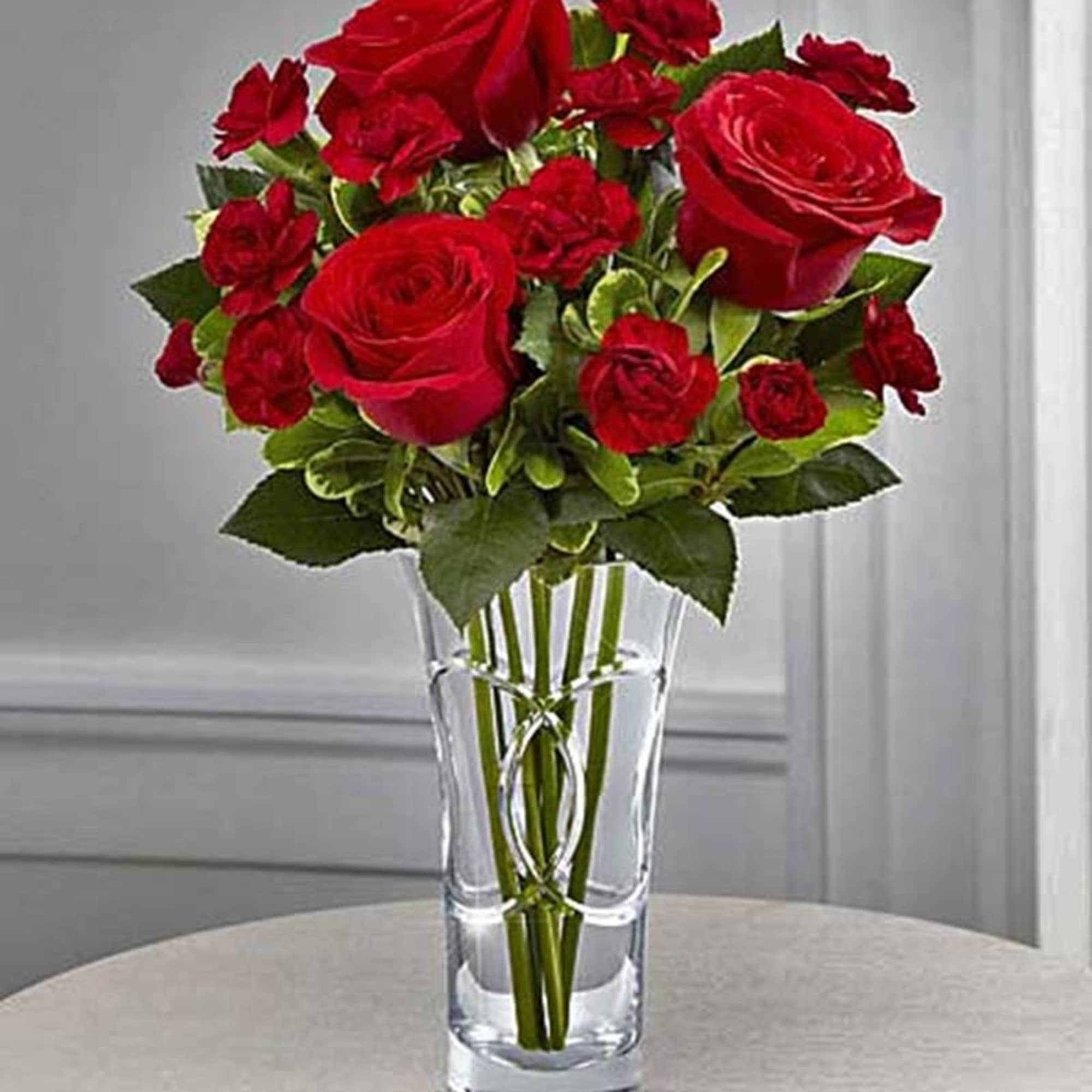 Red roses and carnations in a clear glass vase, photo 3 of 8