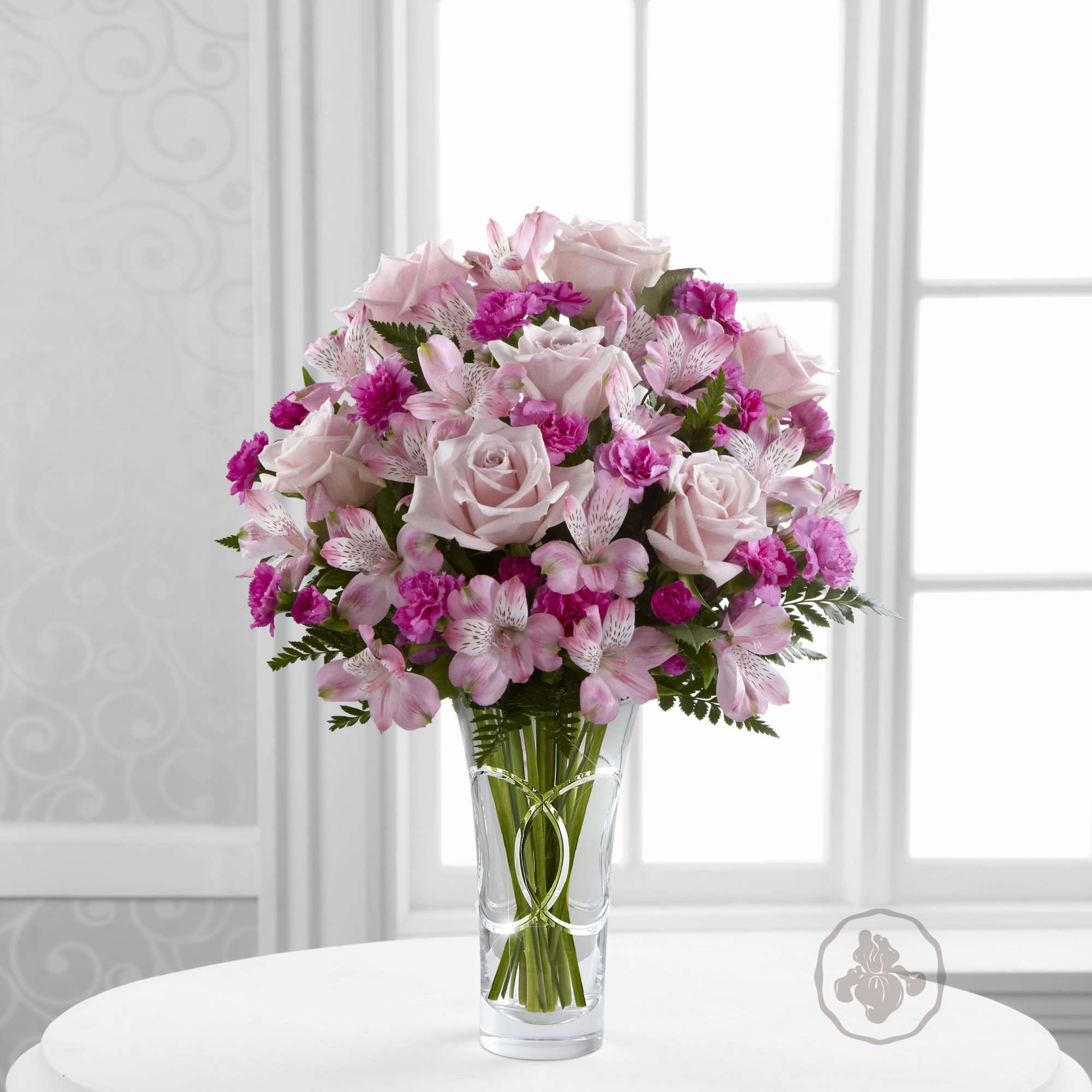 Pink roses and alstroemeria in a clear glass vase