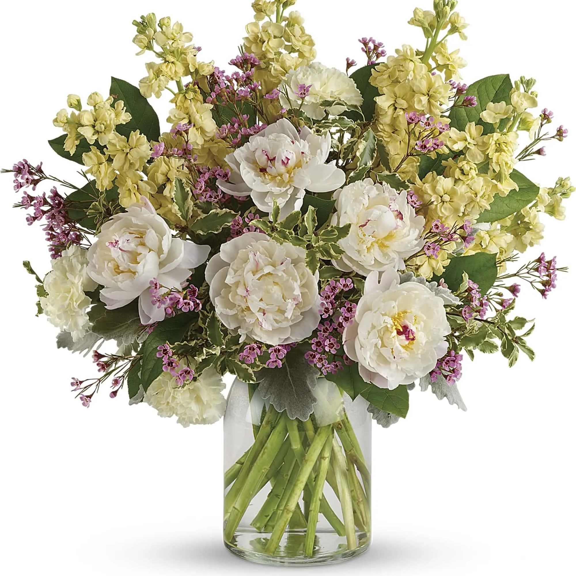 White peonies and pale yellow flowers in a clear glass vase