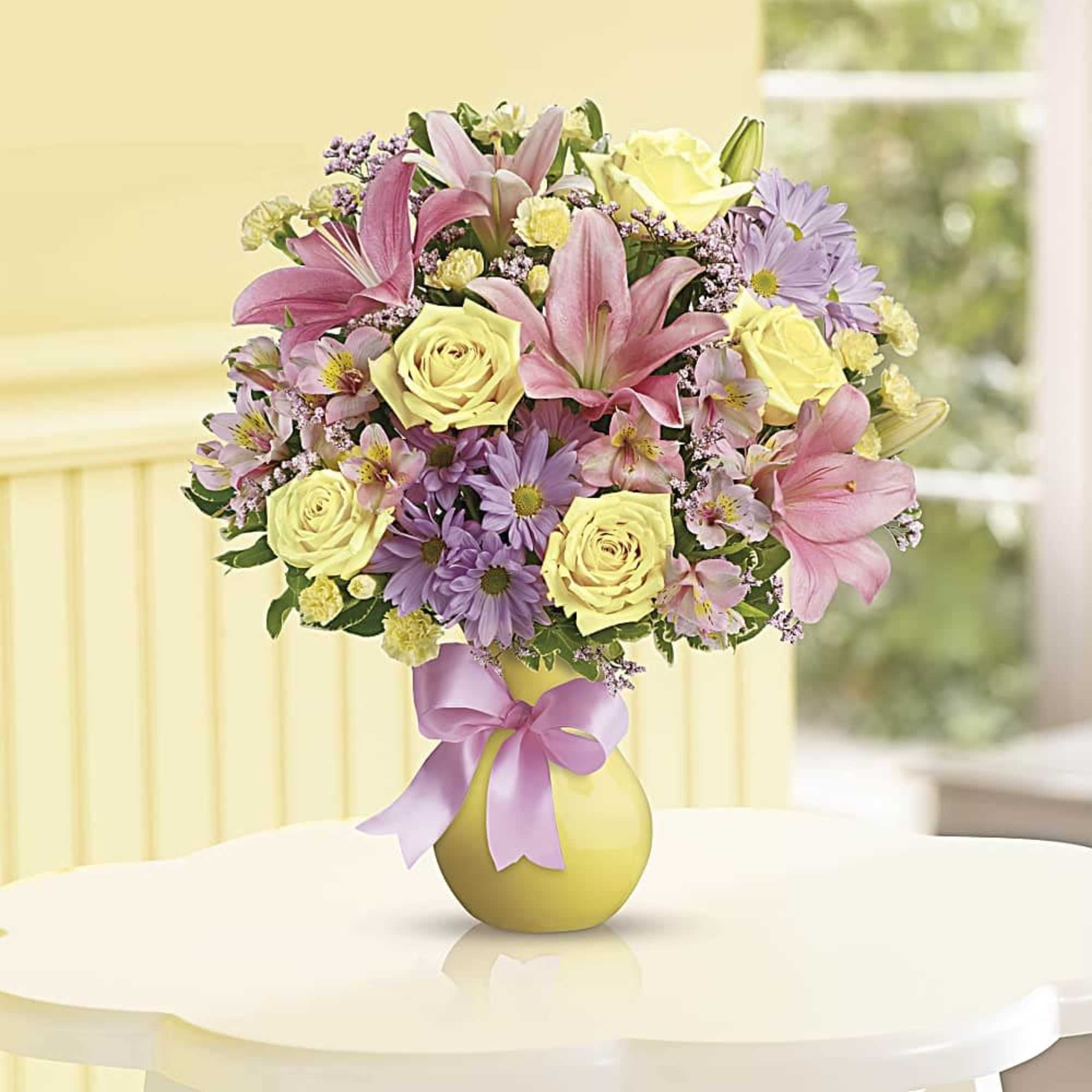 Bouquet of pink lilies, yellow roses, and purple daisies in a yellow vase