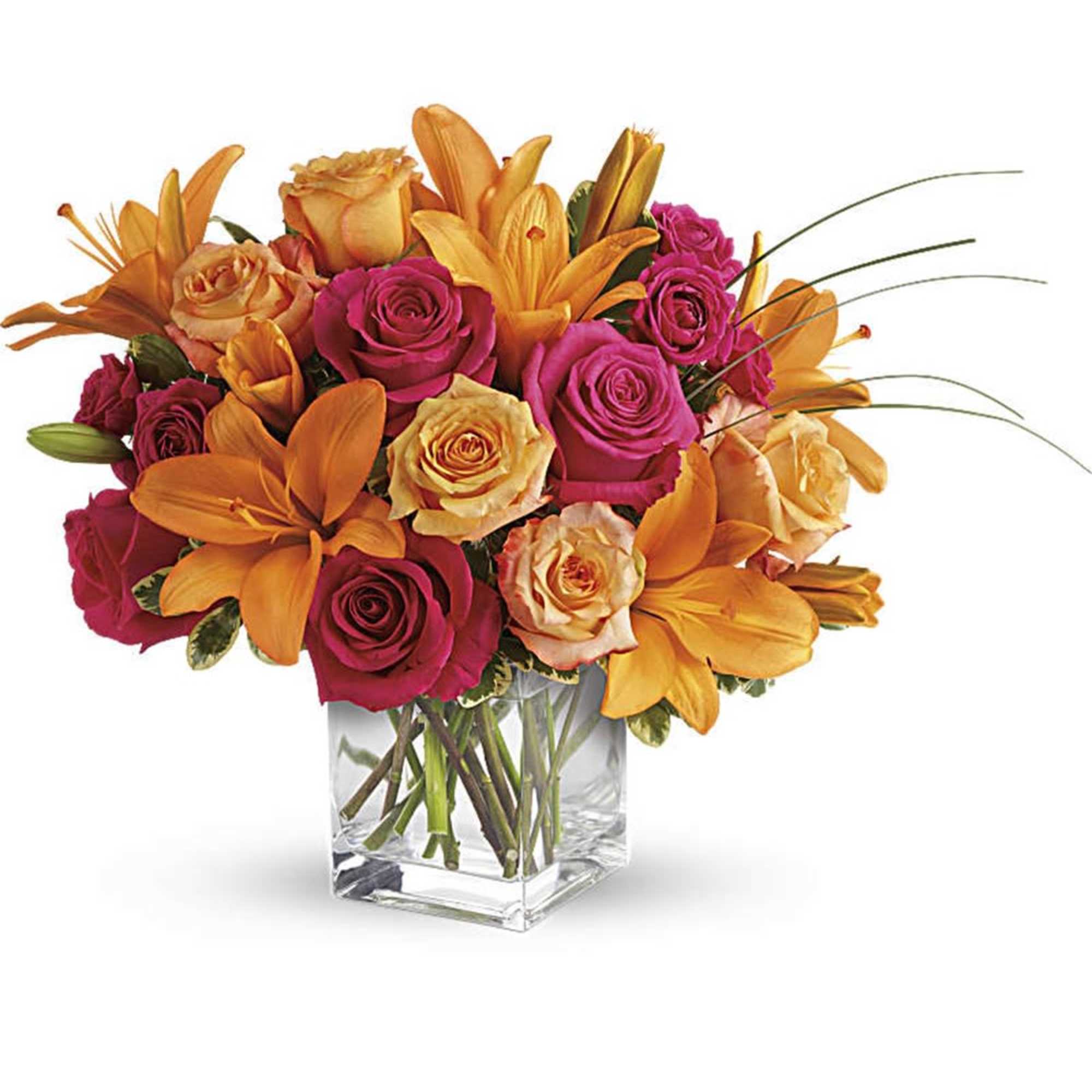 Orange lilies and pink roses arranged in a clear glass vase