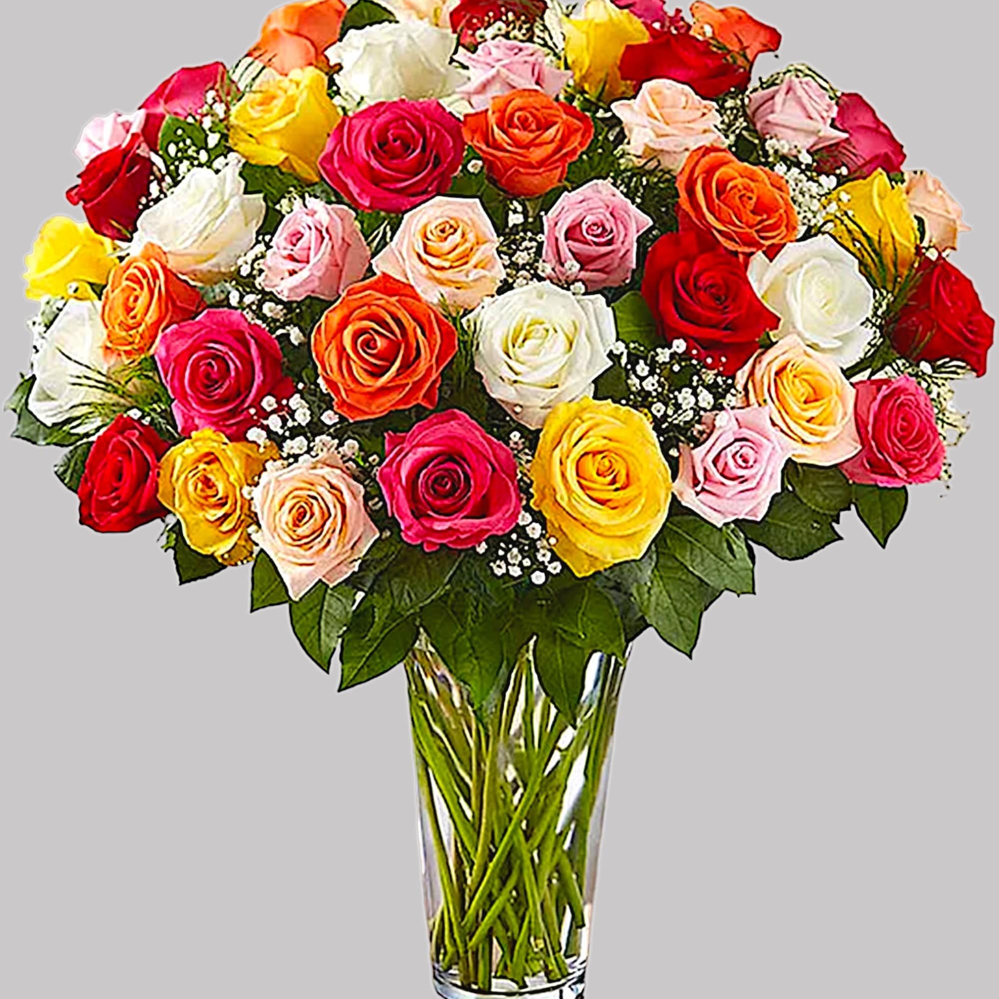 Mixed roses in many colors arranged in a clear glass vase