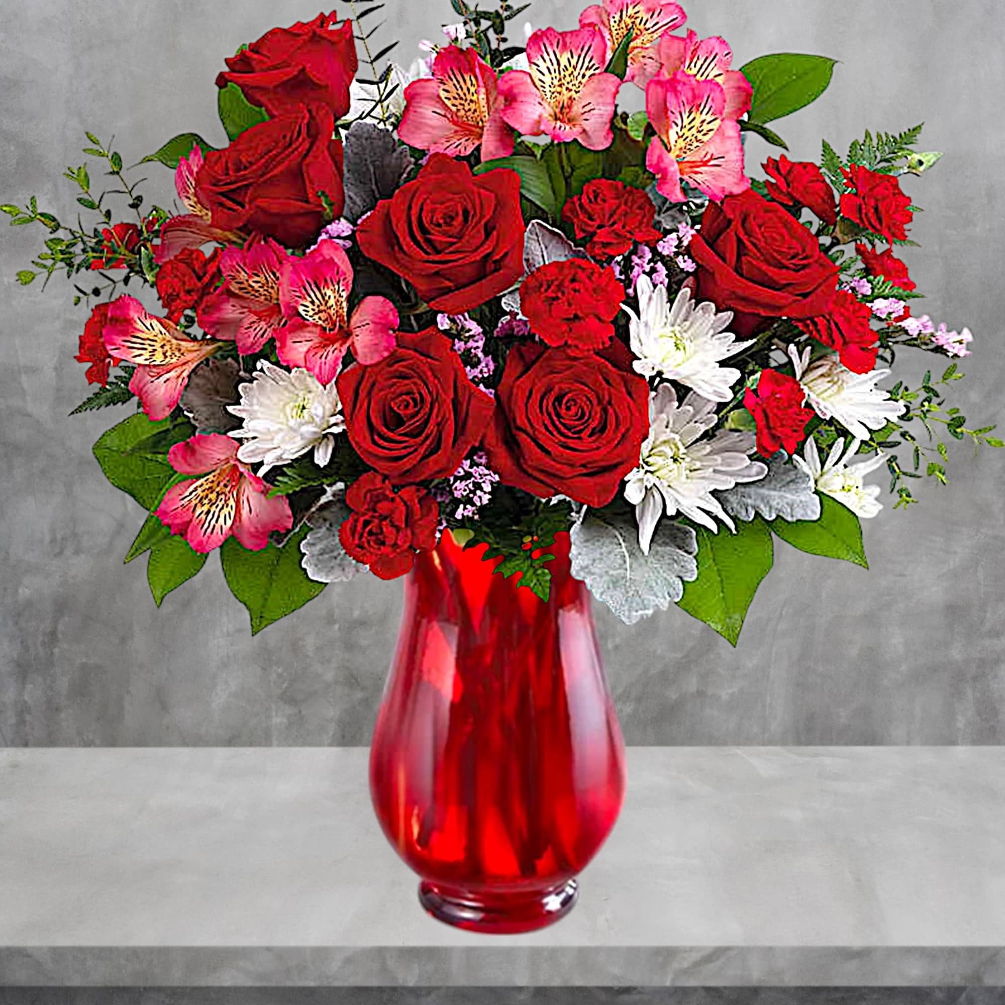 Red roses and pink flowers arranged in a red glass vase, photo 2 of 4