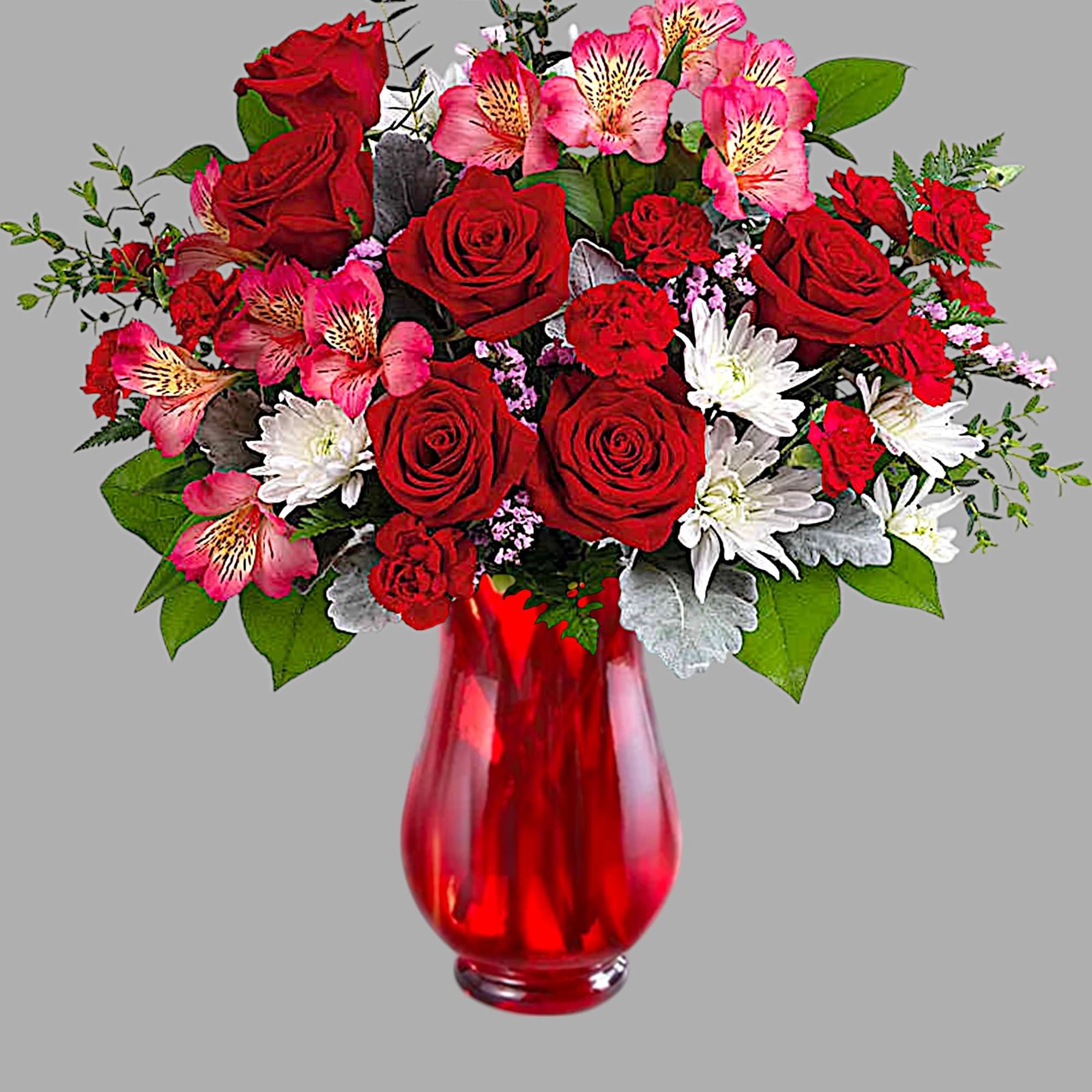 Red roses and pink alstroemeria in a red glass vase
