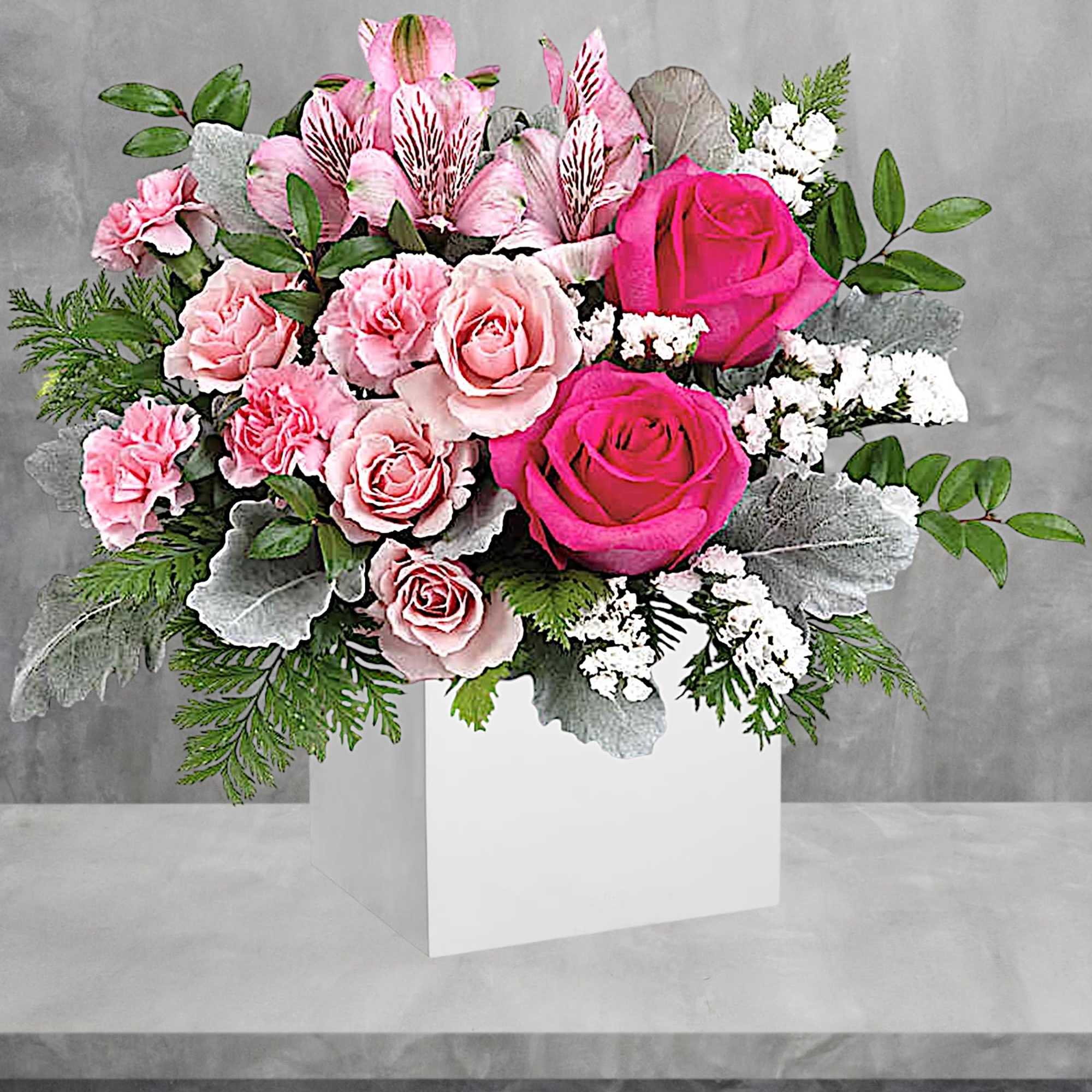 Pink roses and carnations arranged in a white box