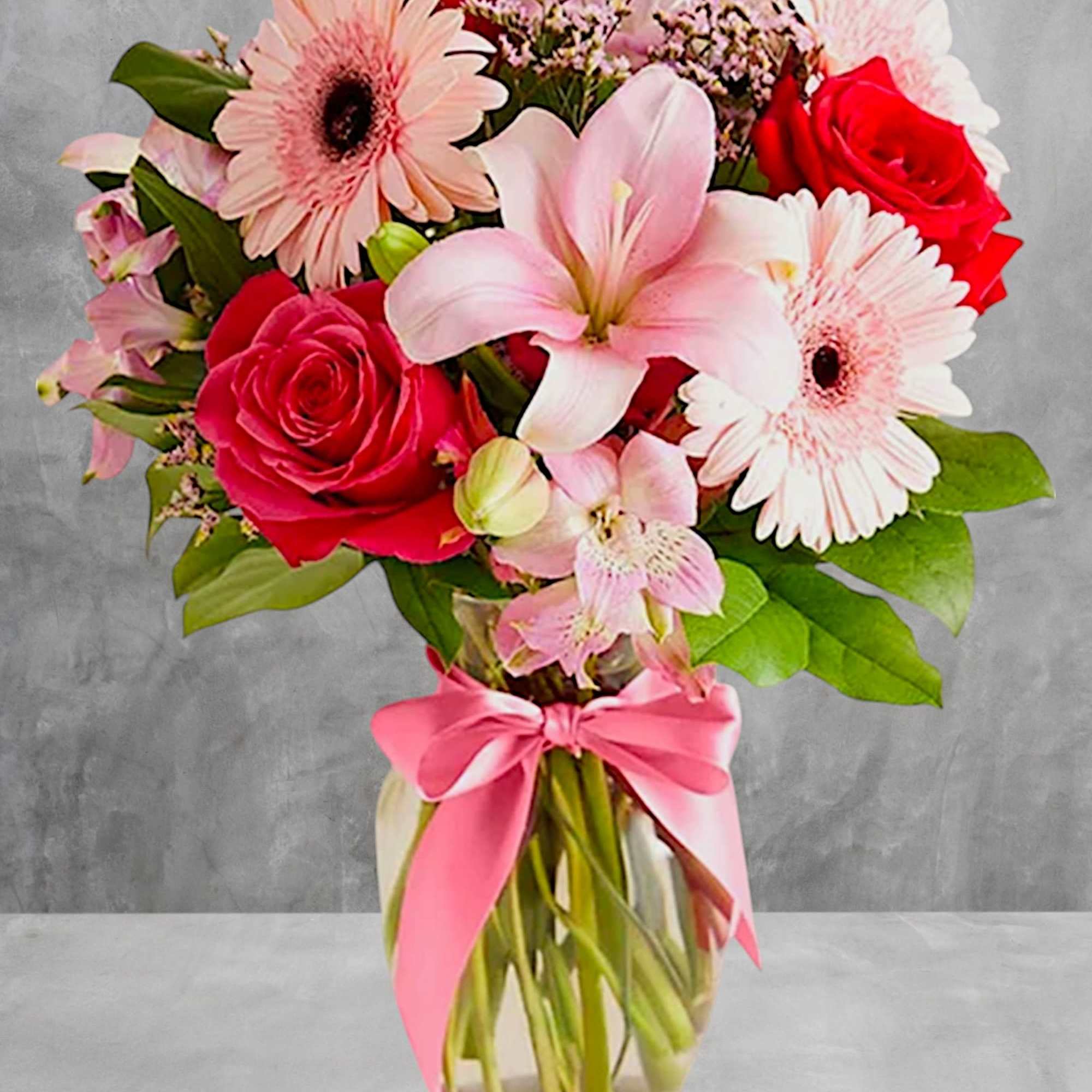 Pink and red mixed bouquet in a glass vase with a pink ribbon, photo 2 of 4
