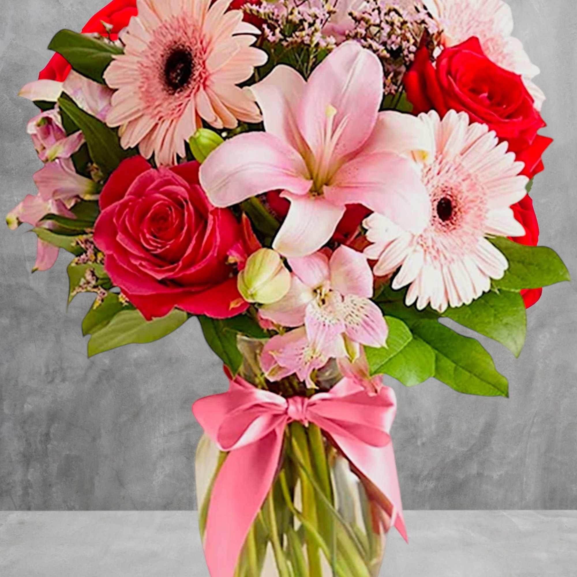 Bouquet of pink lilies, red roses, and pale gerbera daisies in a glass vase, photo 2 of 4