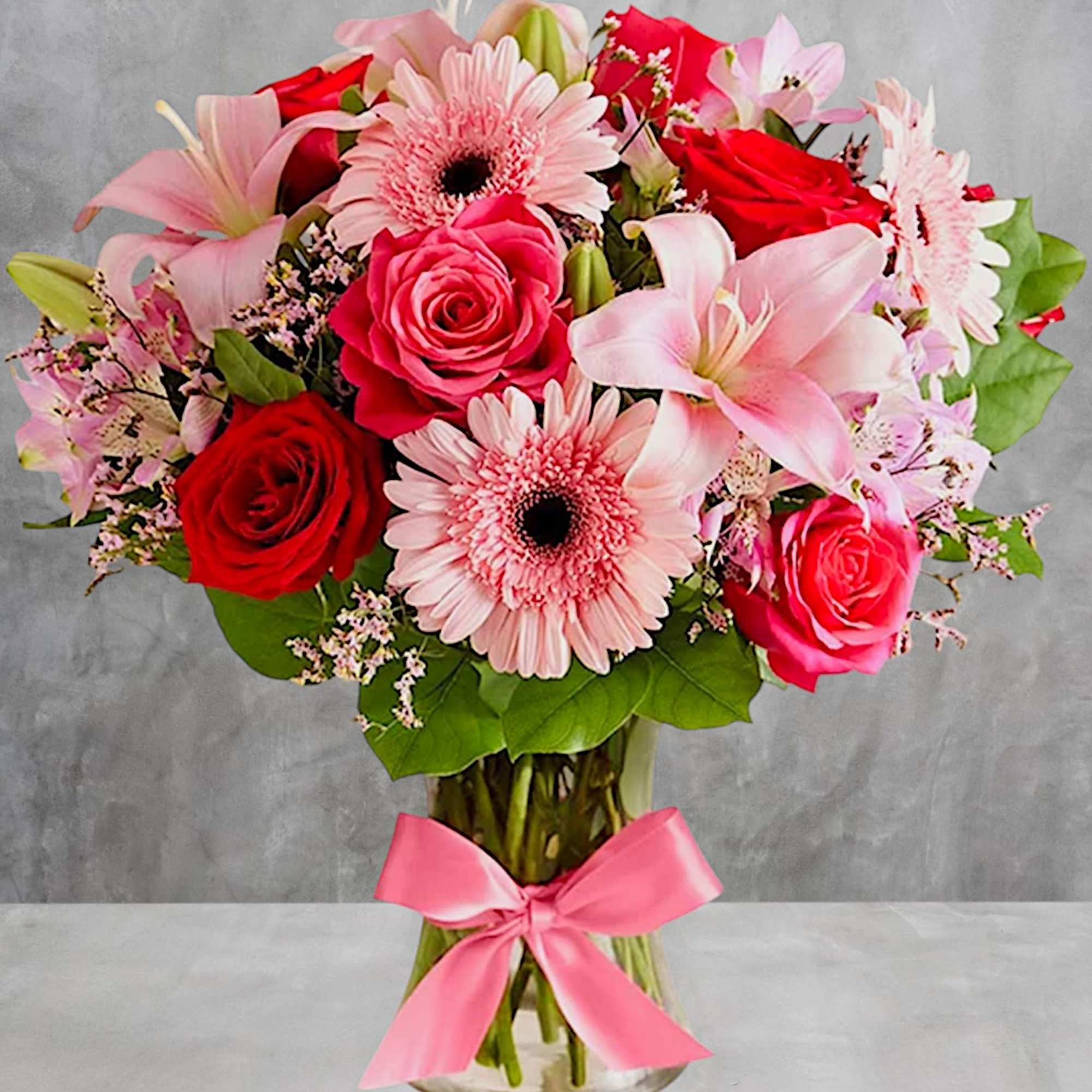 Pink and red mixed bouquet in a glass vase with a pink ribbon, photo 2 of 5