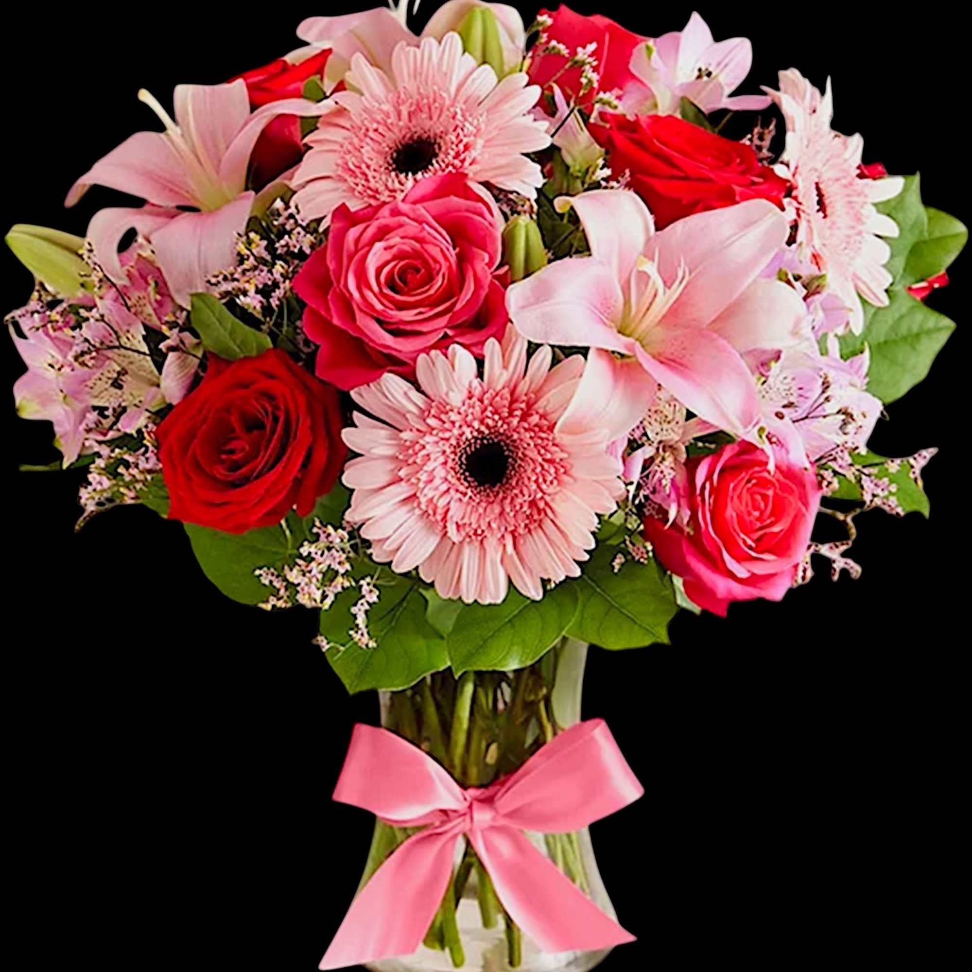 Pink and red mixed bouquet in a clear glass vase with a pink ribbon