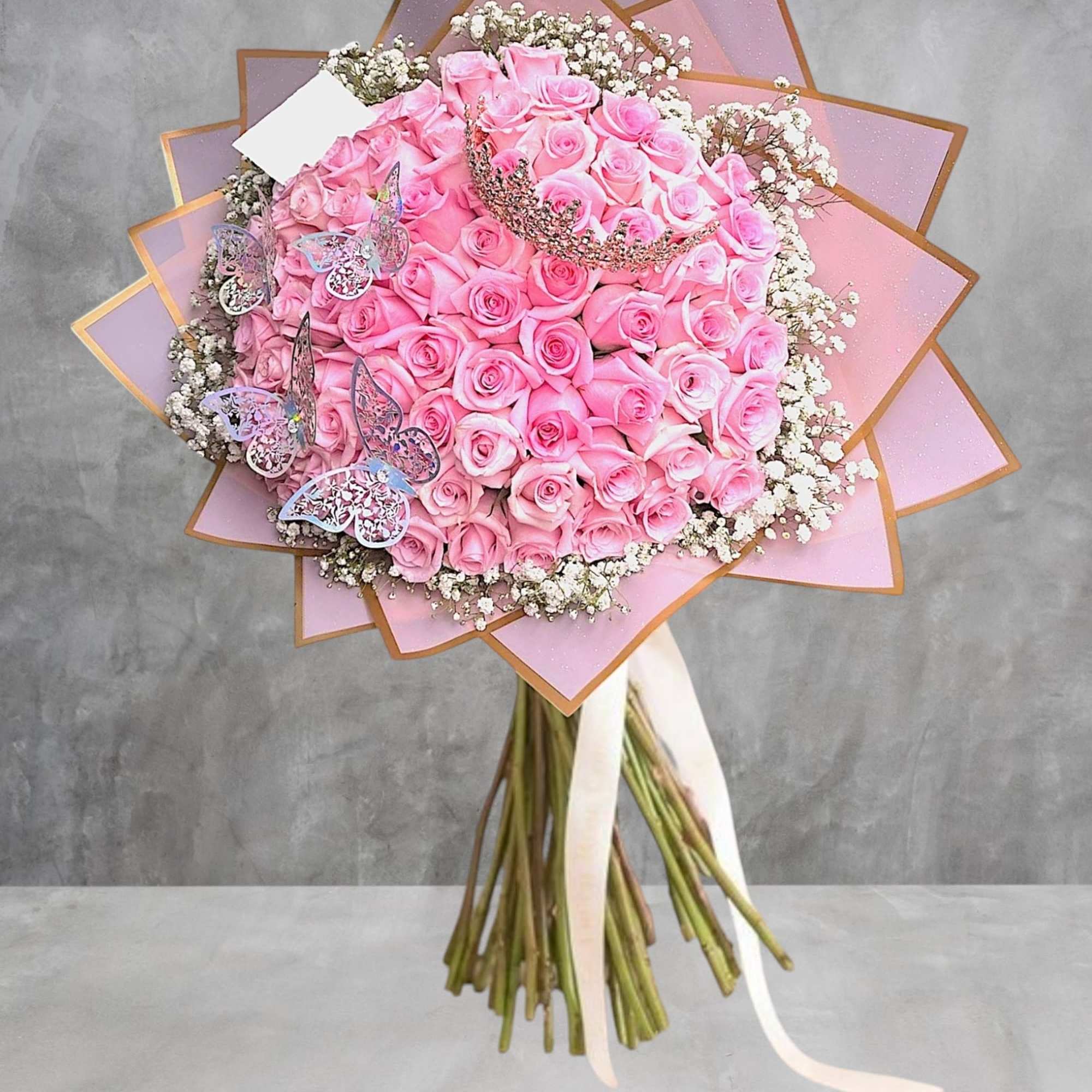 Large bouquet of pink roses with baby’s breath and butterfly decorations