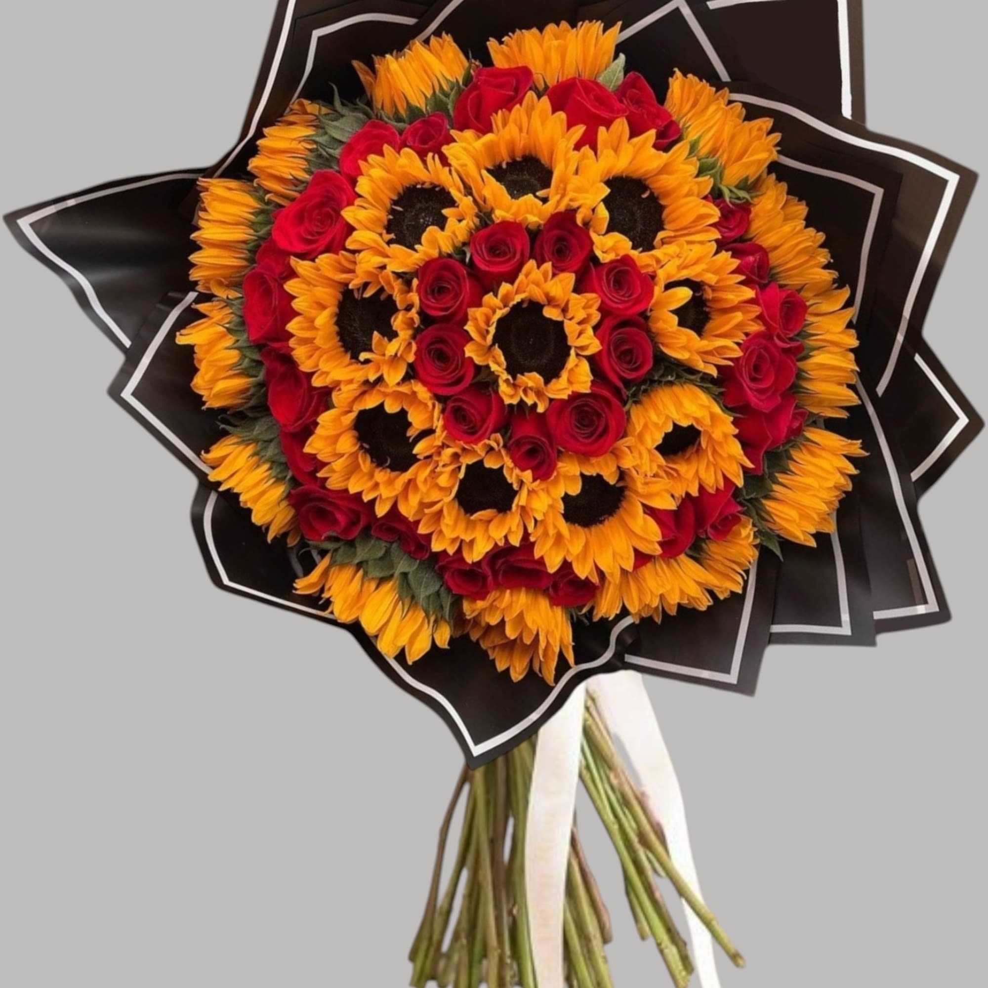 Bouquet of red roses and orange sunflowers wrapped in black paper